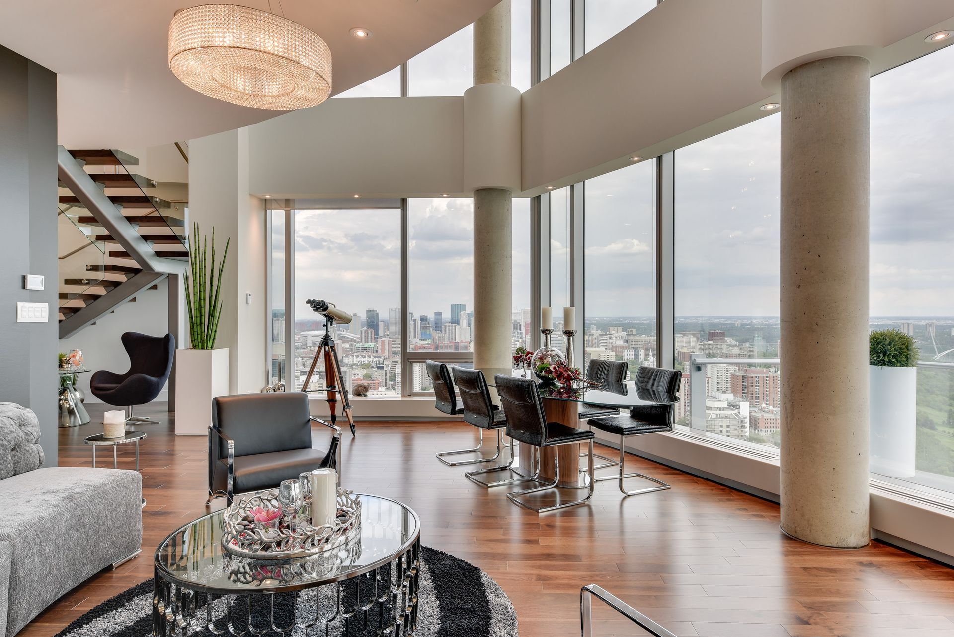 A living room with a lot of windows and a view of the city.