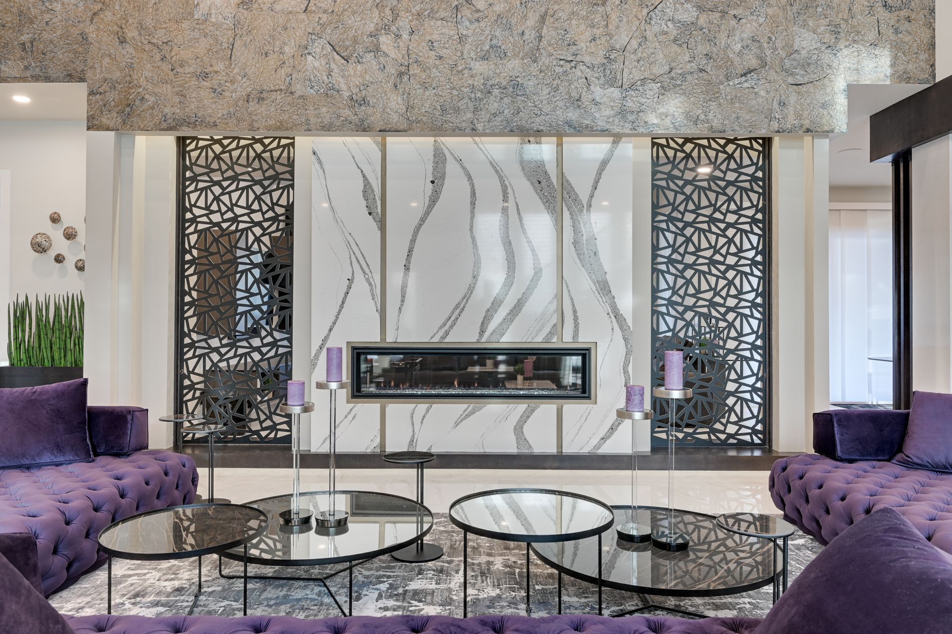 A living room with purple furniture and a fireplace.
