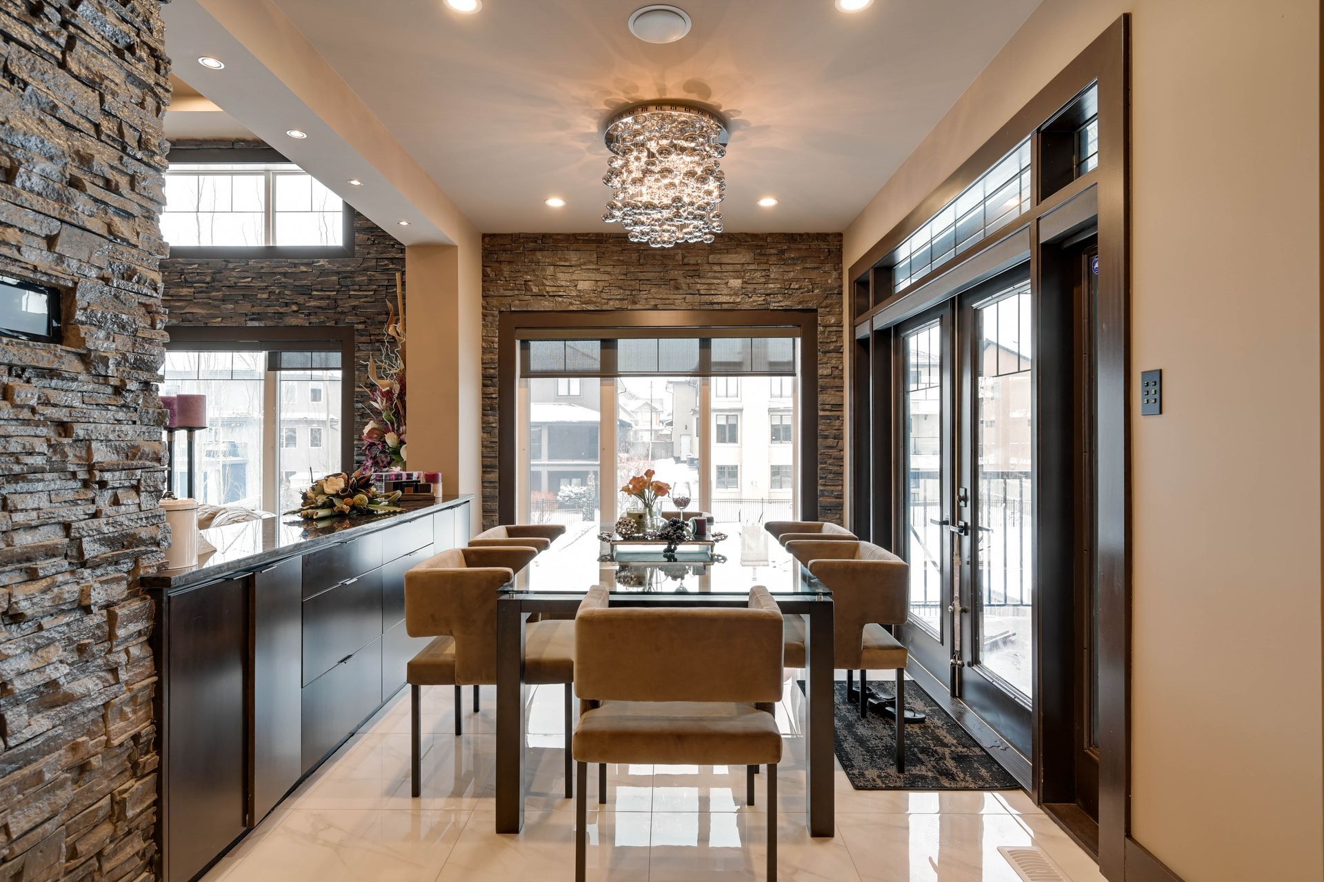 A dining room with a table and chairs and a chandelier hanging from the ceiling.