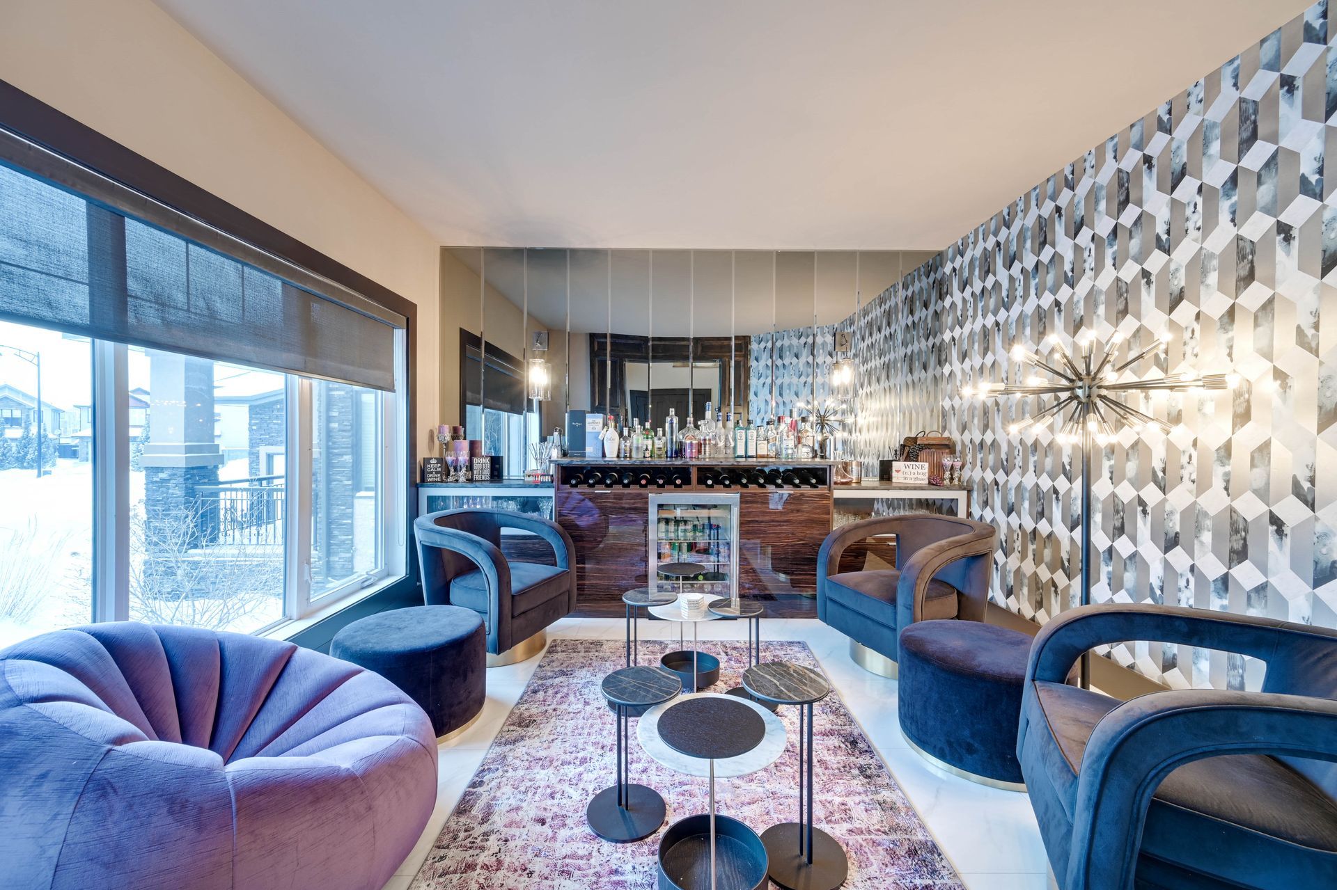 A living room with purple chairs and ottomans and a bar