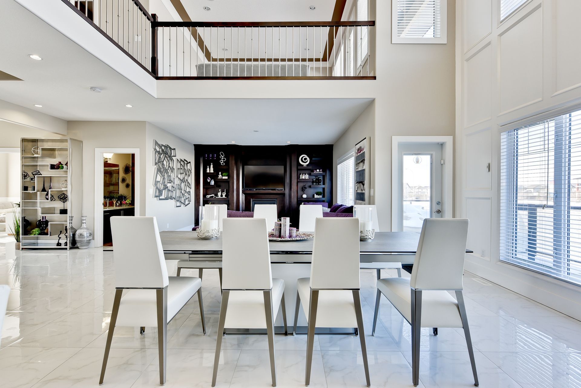 A dining room with a table and chairs and a balcony