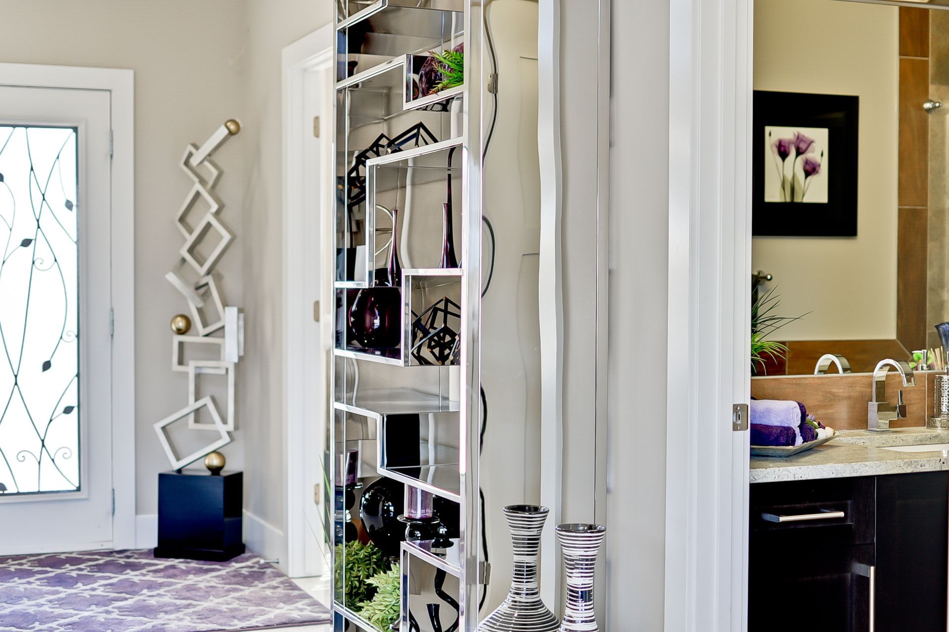 A bathroom with a mirror and a shelf with vases on it