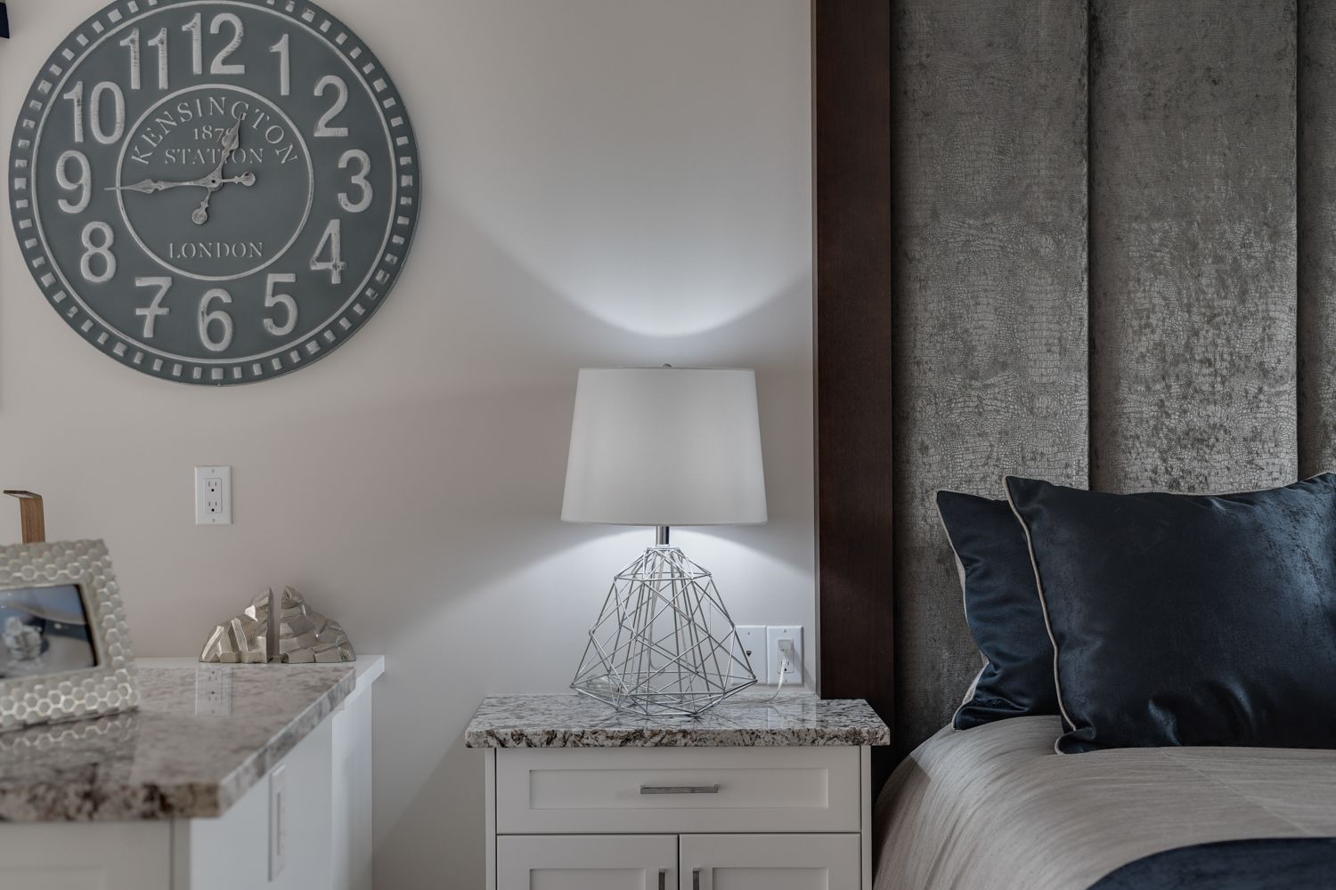 A bedroom with a large clock on the wall above the bed