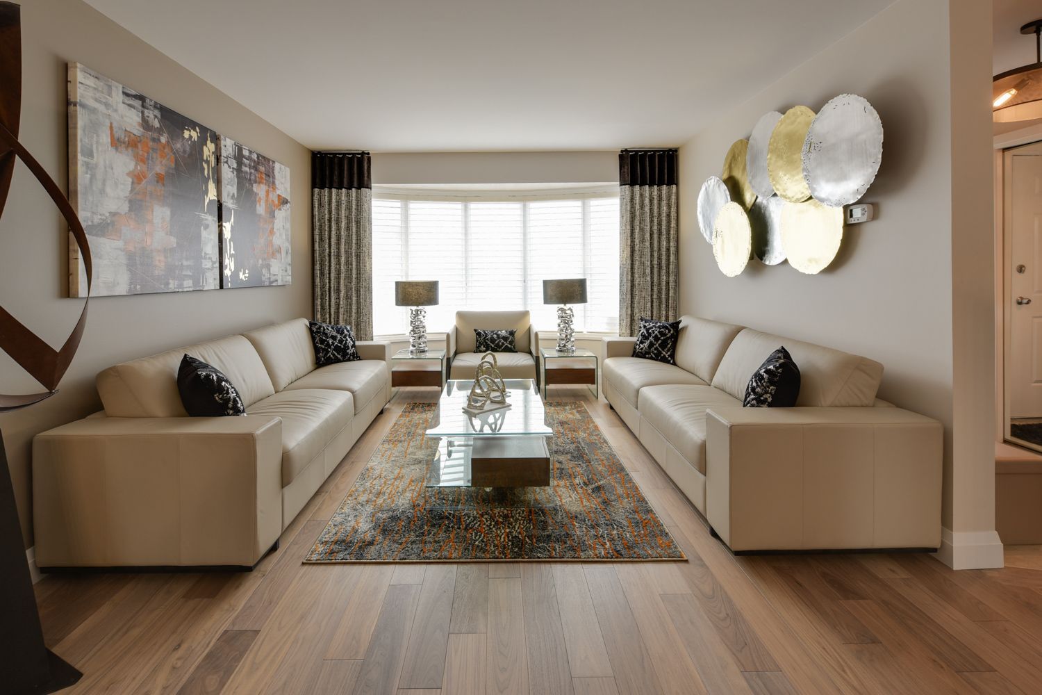 A living room with two couches , a coffee table , and a painting on the wall.