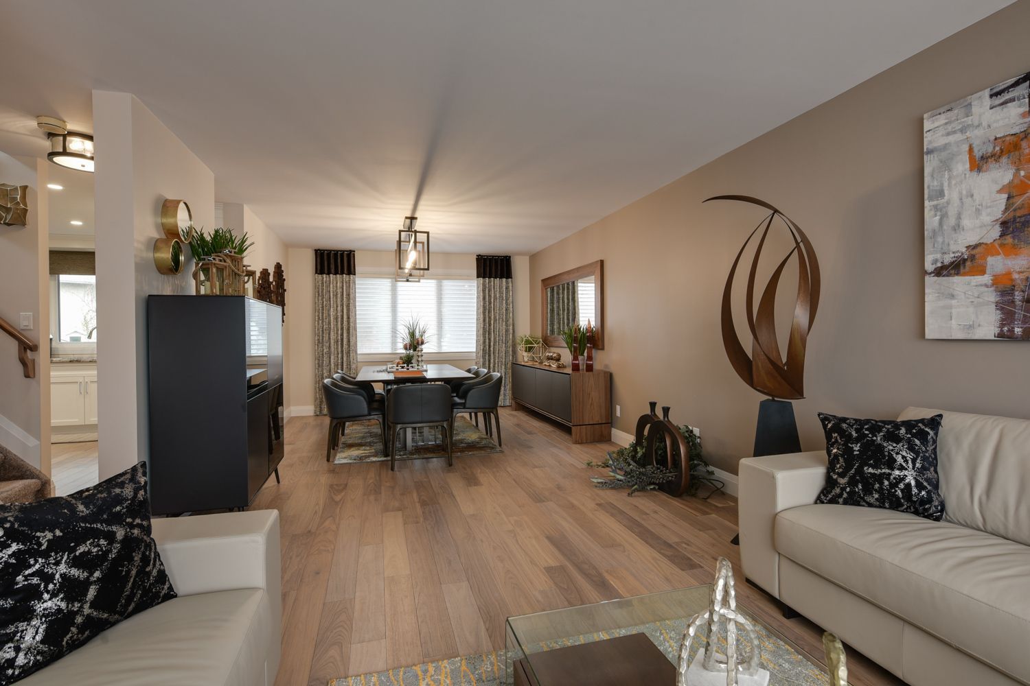 A living room with a couch , table and chairs and a dining room with a table and chairs.
