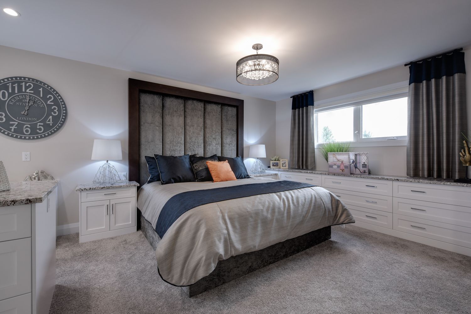 A bedroom with a large bed and a clock on the wall.