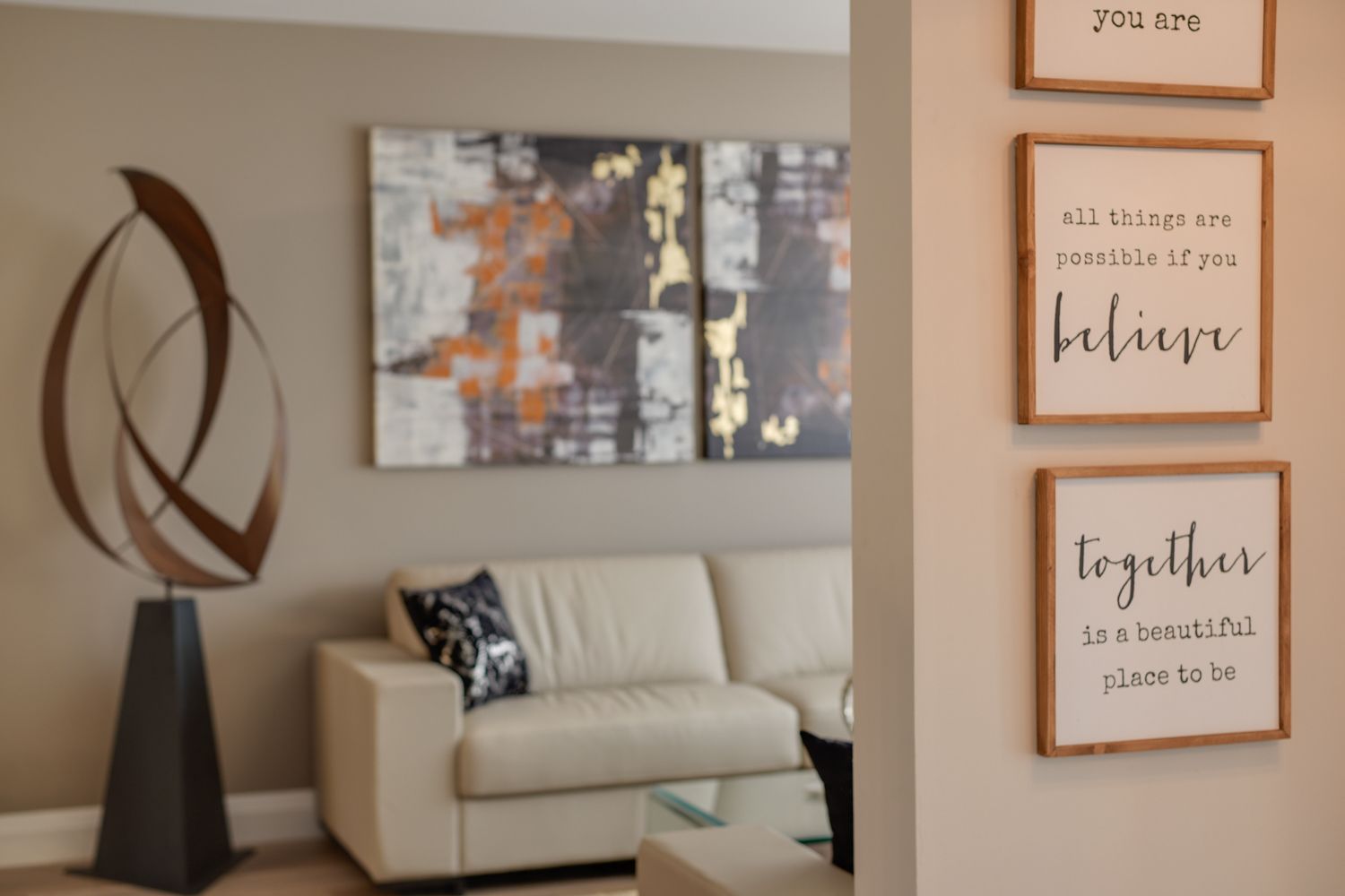 A living room with a couch and three signs on the wall