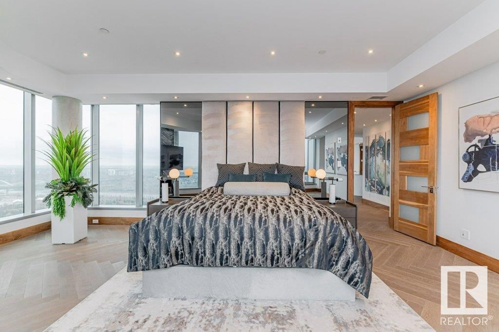 A bedroom with a large bed and lots of windows