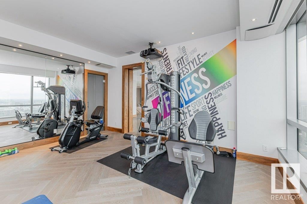A gym with a large mirror and a mural on the wall.