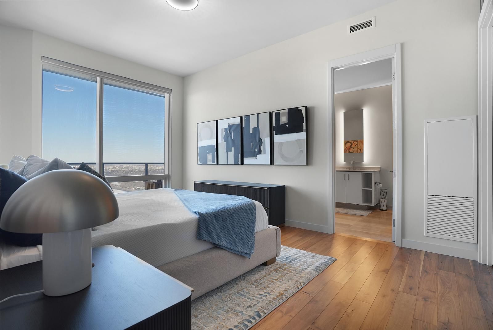 A bedroom with a large bed and a large window.