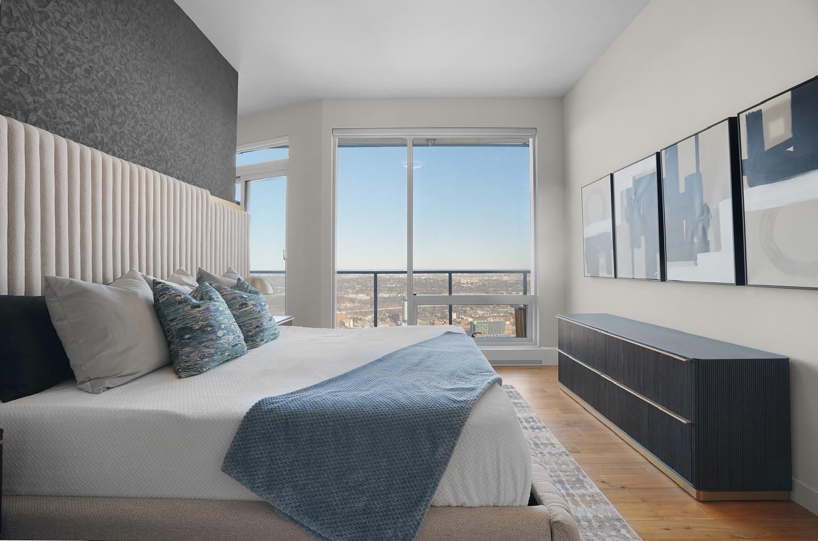 A bedroom with a large bed and a large window.