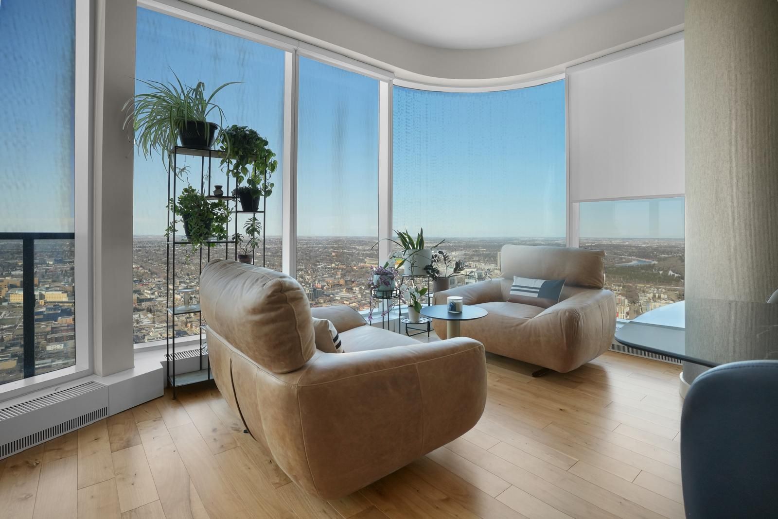 A living room with a lot of windows and a view of the city.