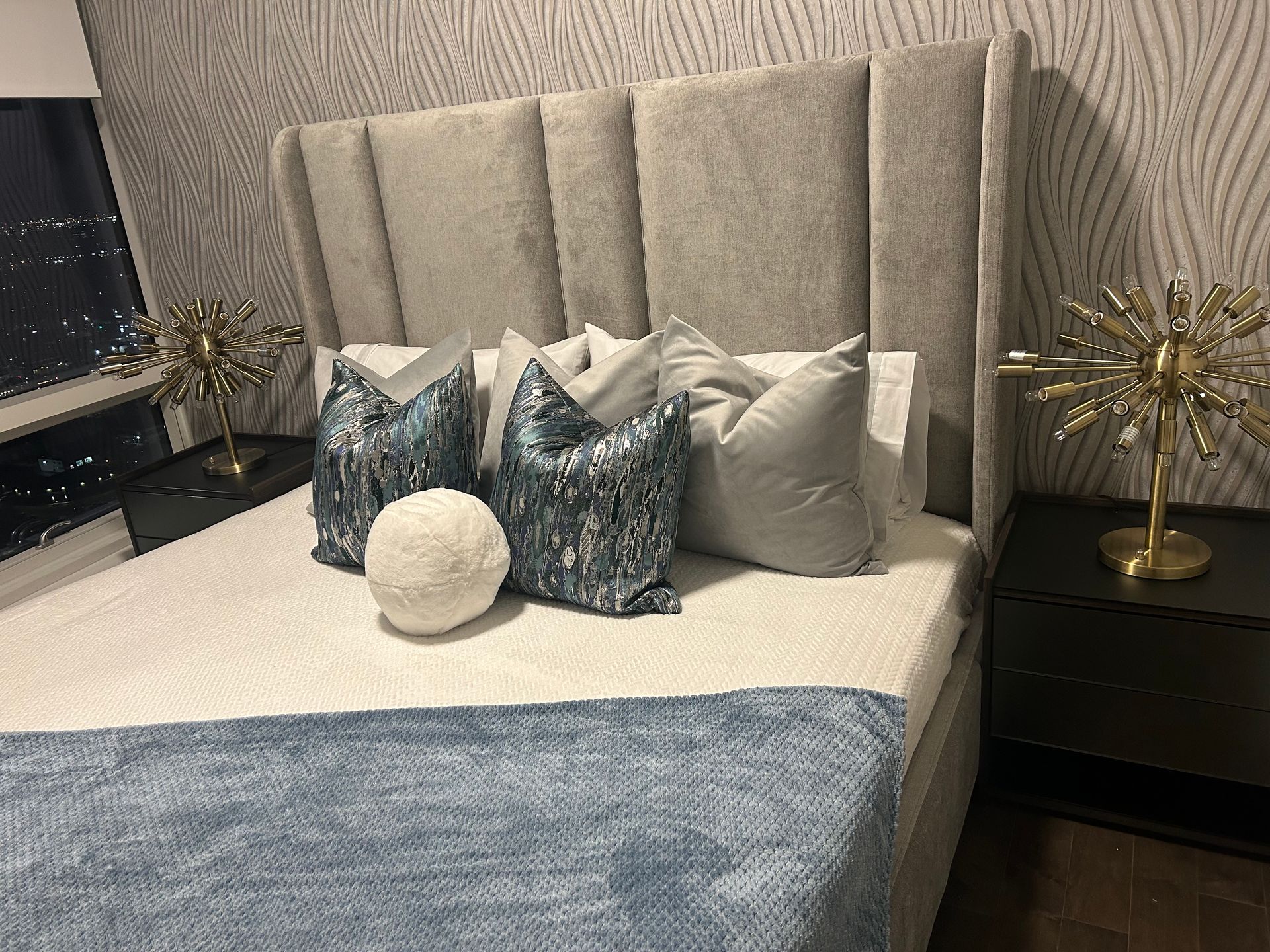 A bed with a headboard and pillows on it in a bedroom.