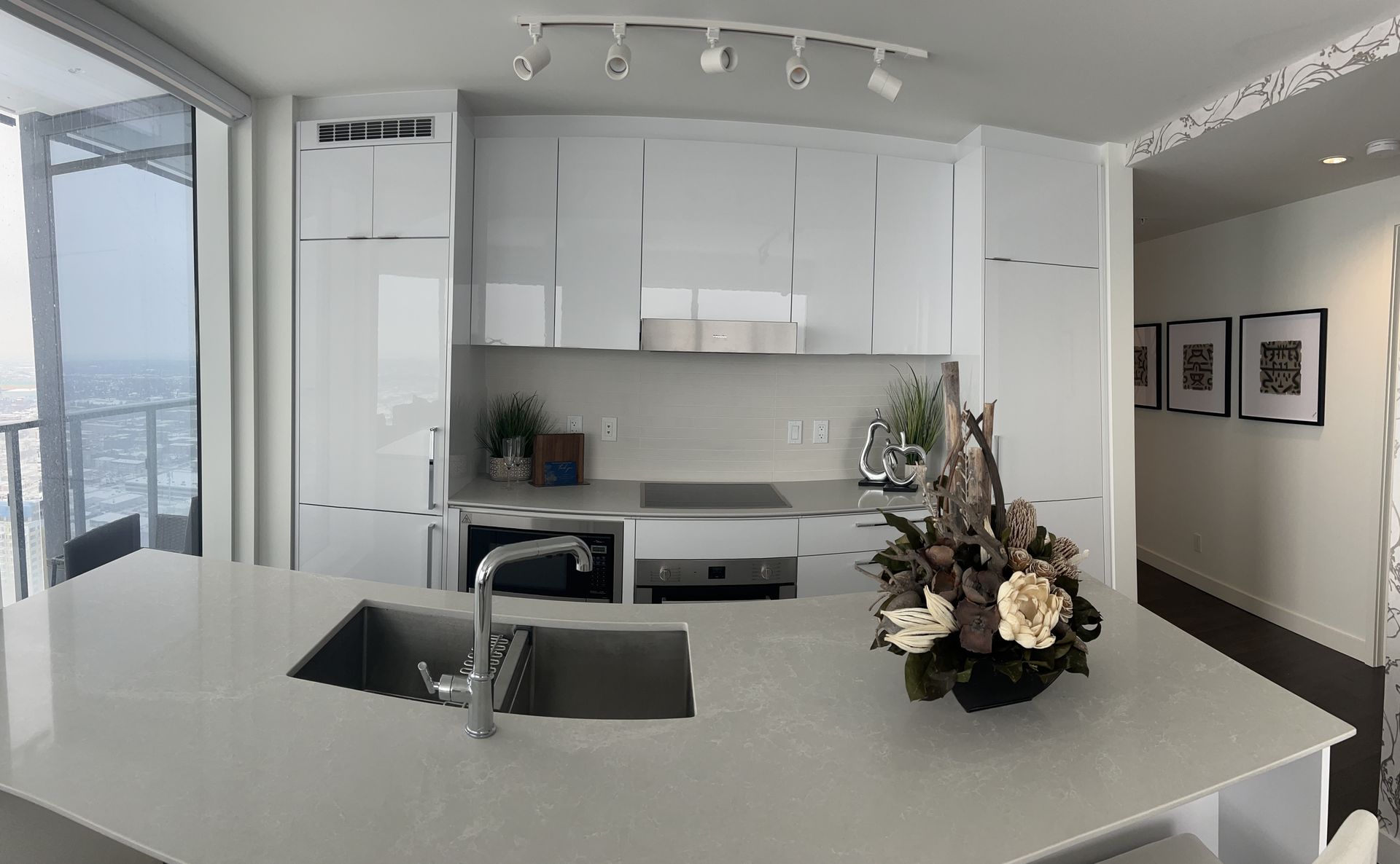 A kitchen with white cabinets and a stainless steel sink