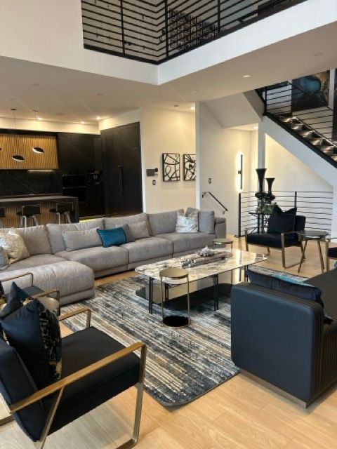 A living room with a large sectional couch and chairs