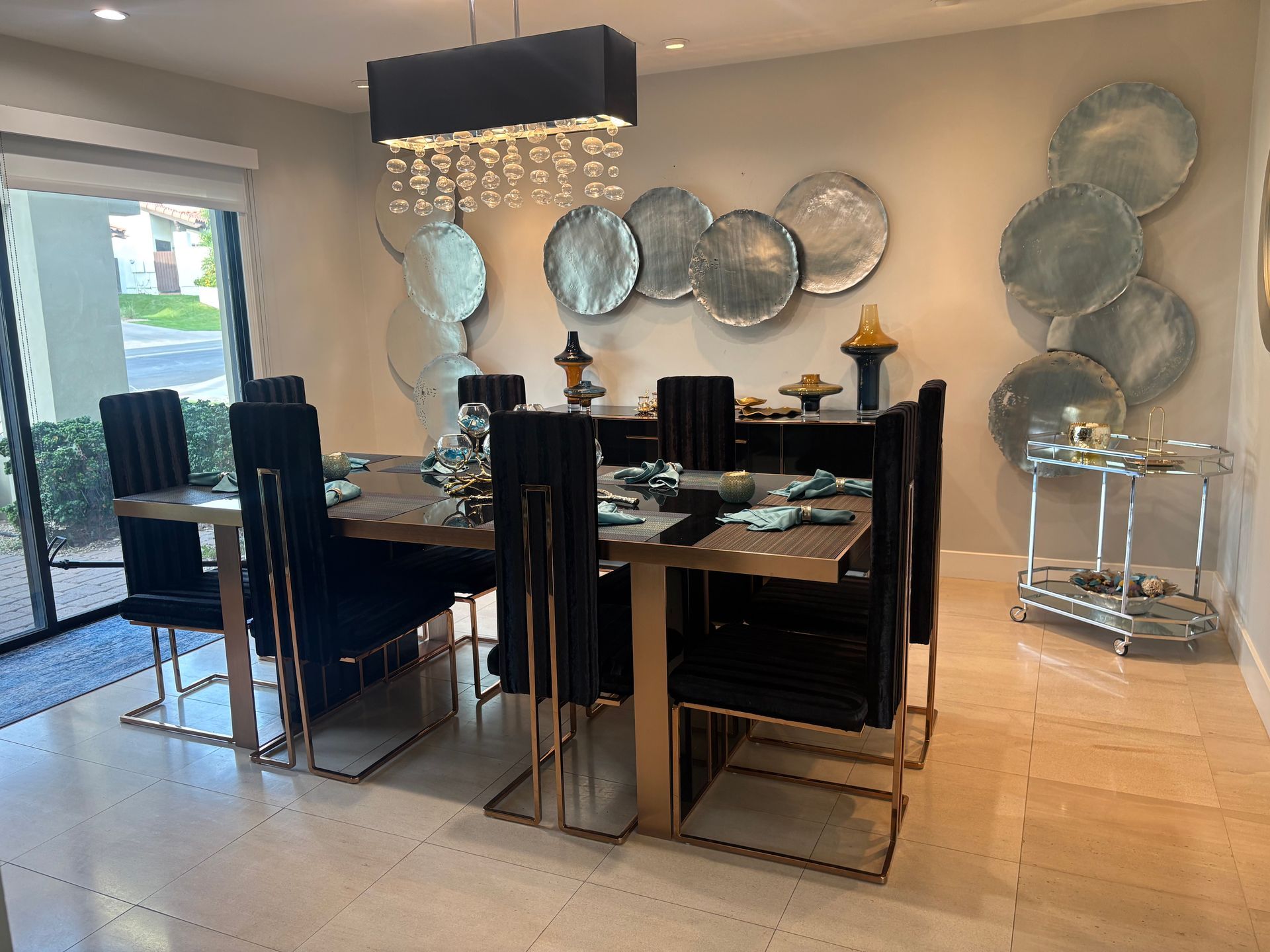 Dining room with a long table, black chairs, and decorative wall plates.
