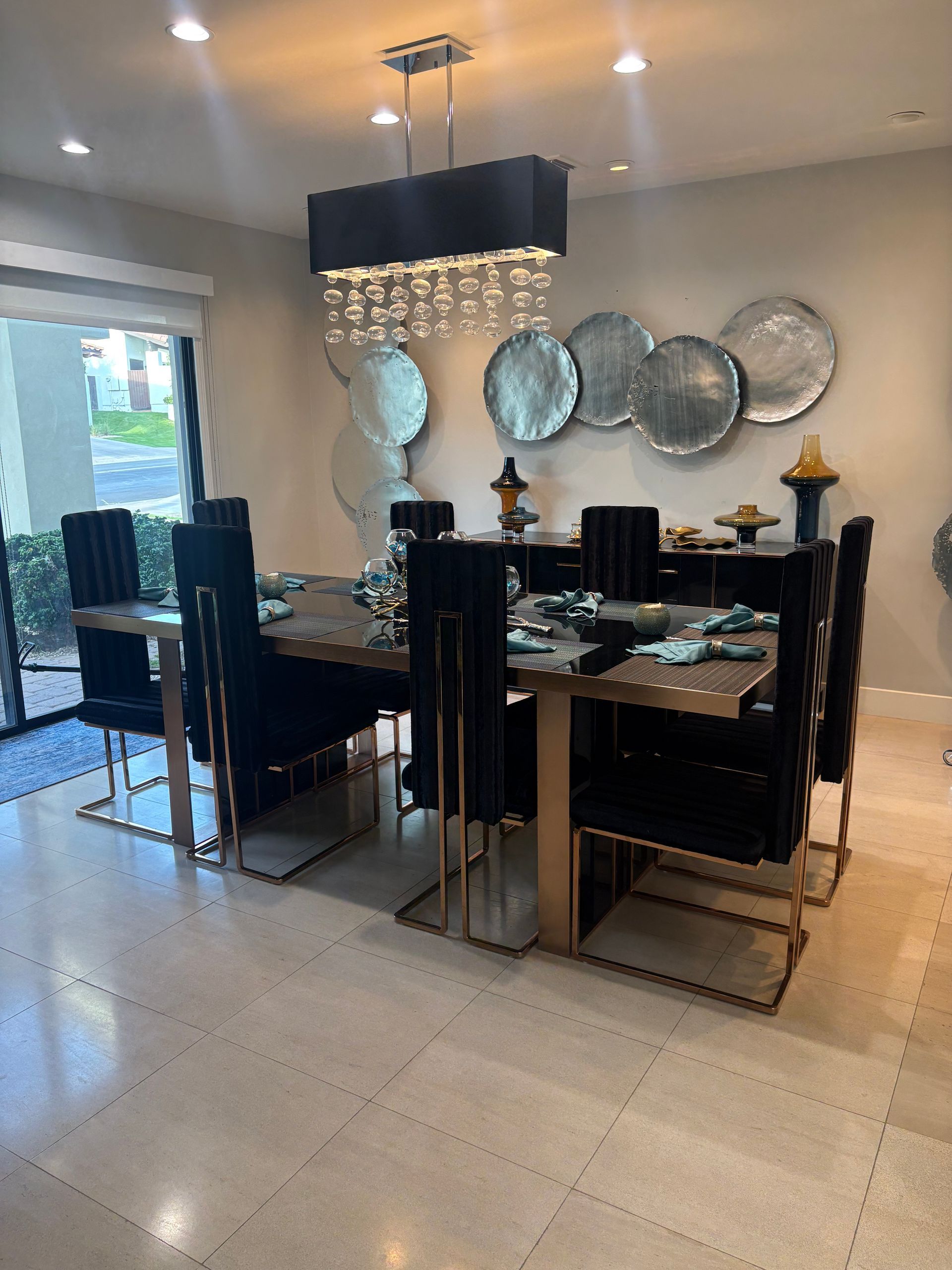 Dining room with wooden table, black chairs, and decorative wall art.