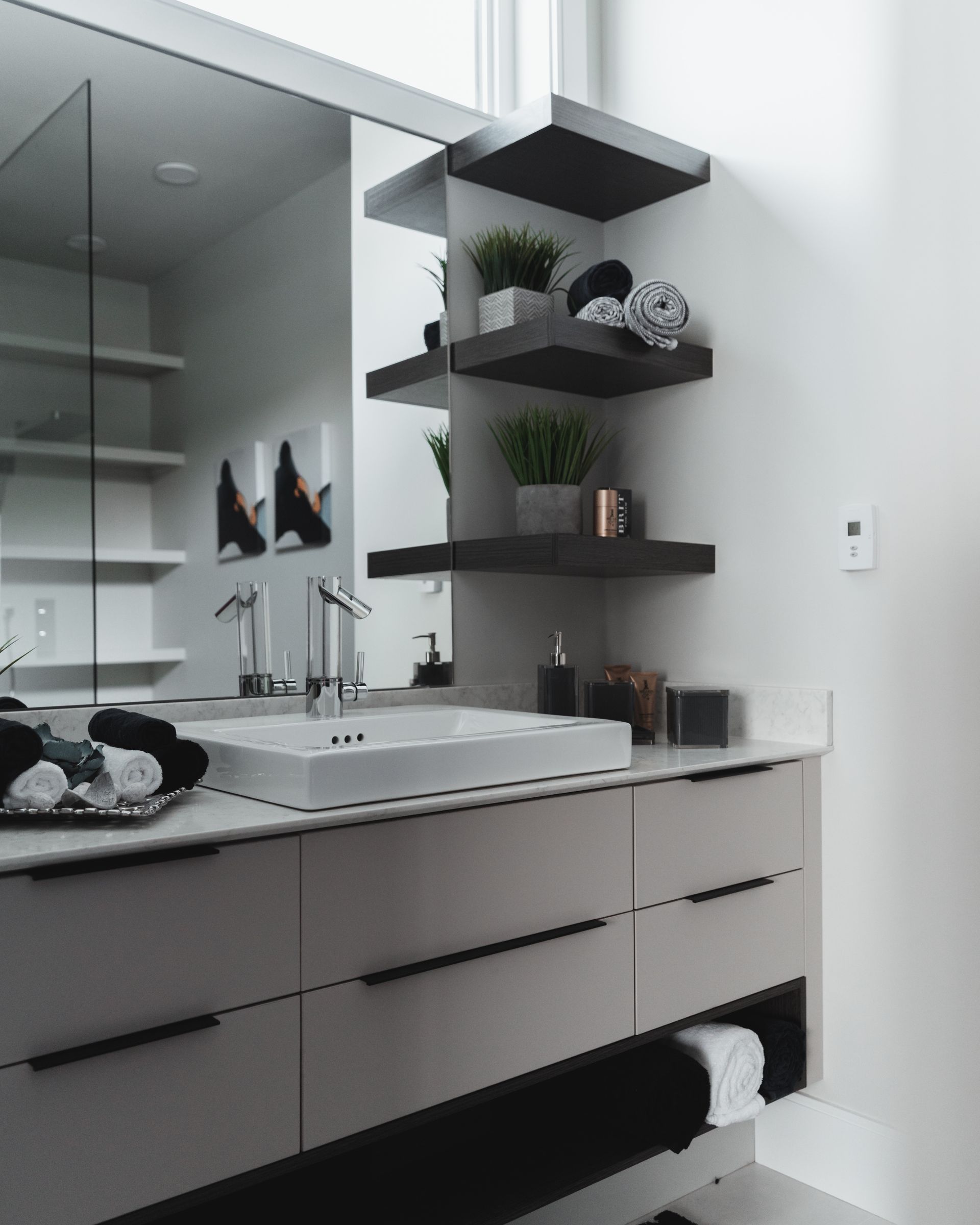 A bathroom with a sink , mirror and shelves