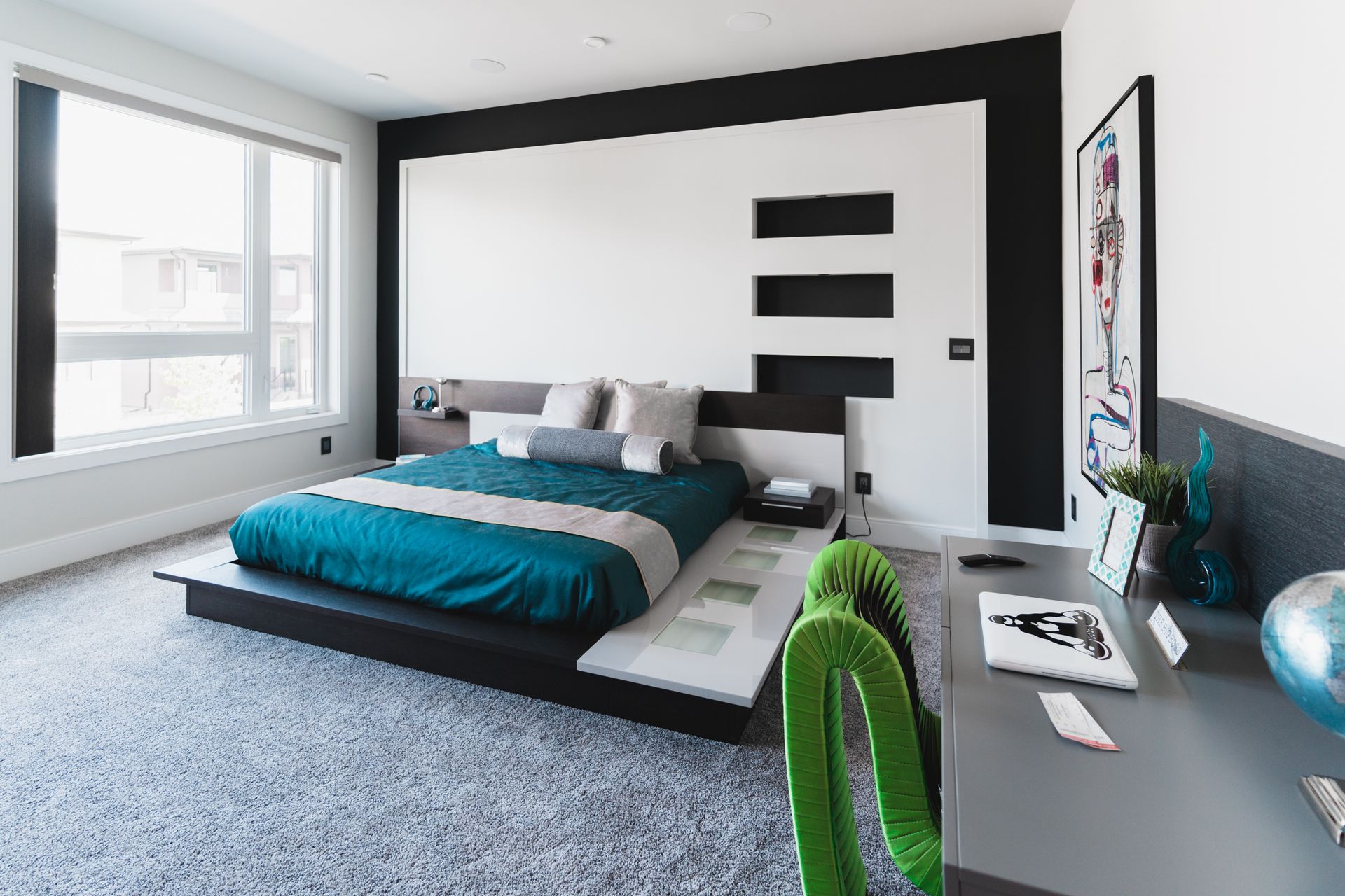A bedroom with a large bed and a desk.