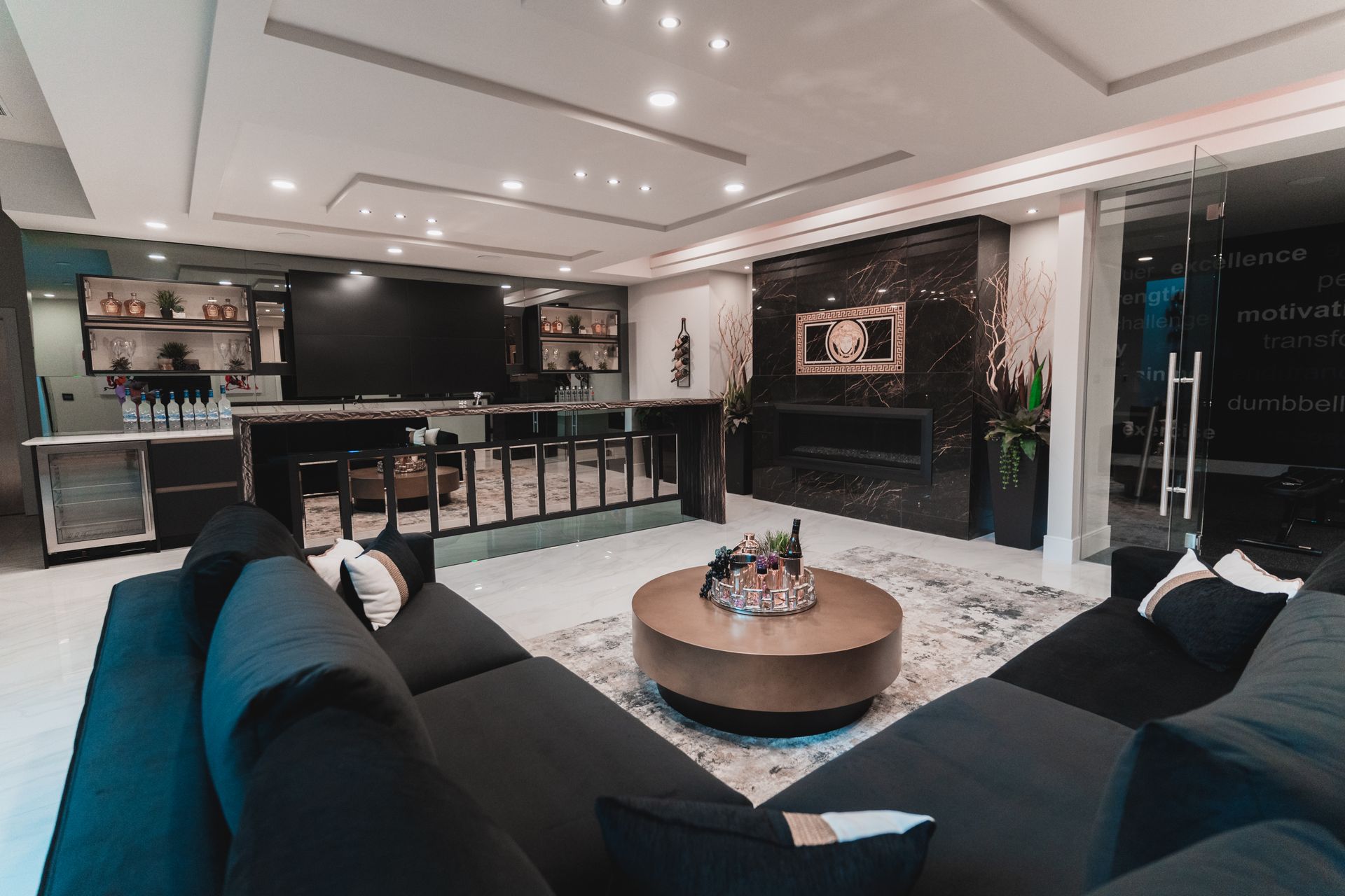 A living room with two black couches and a round coffee table.