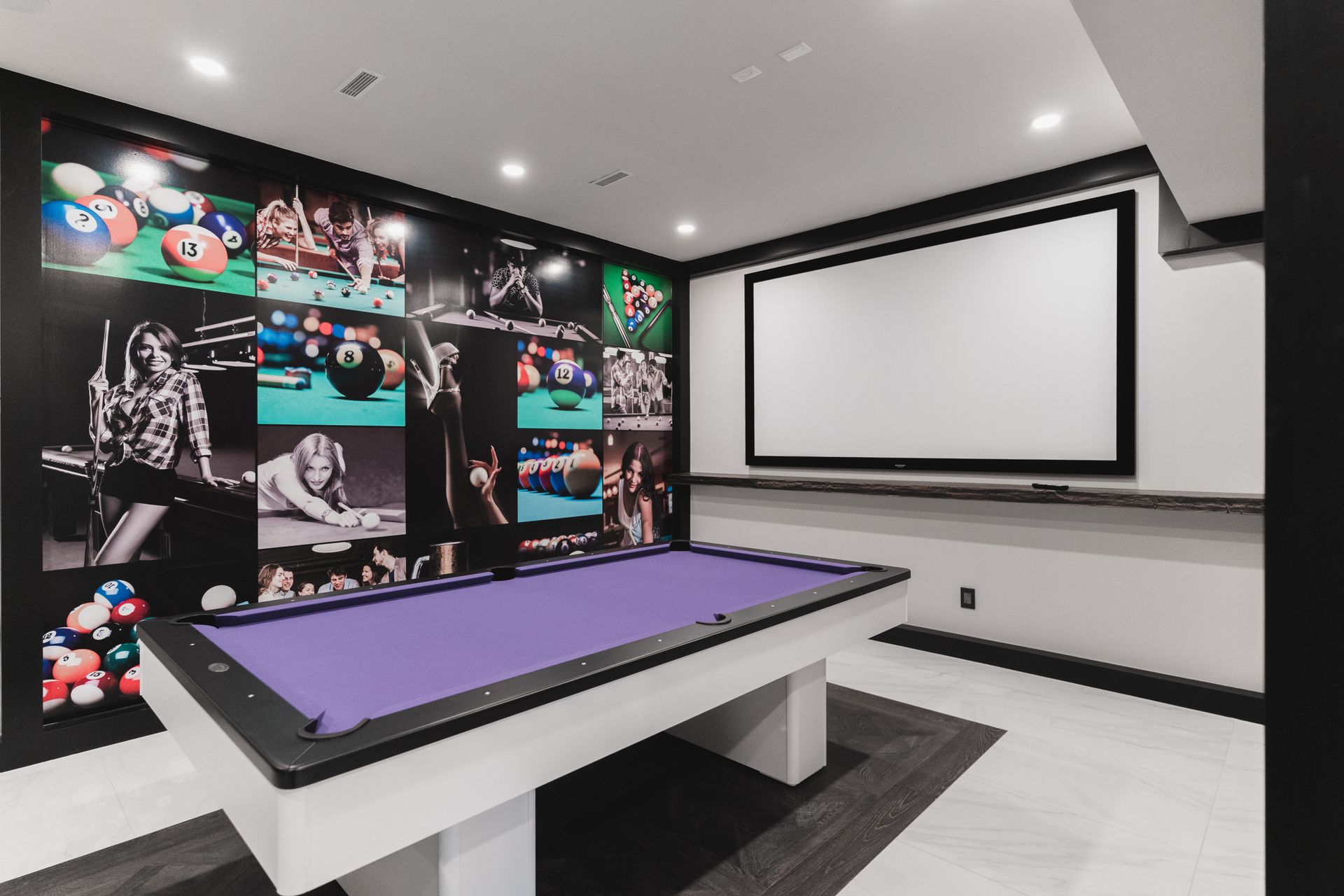 A pool table in a room with a projector screen
