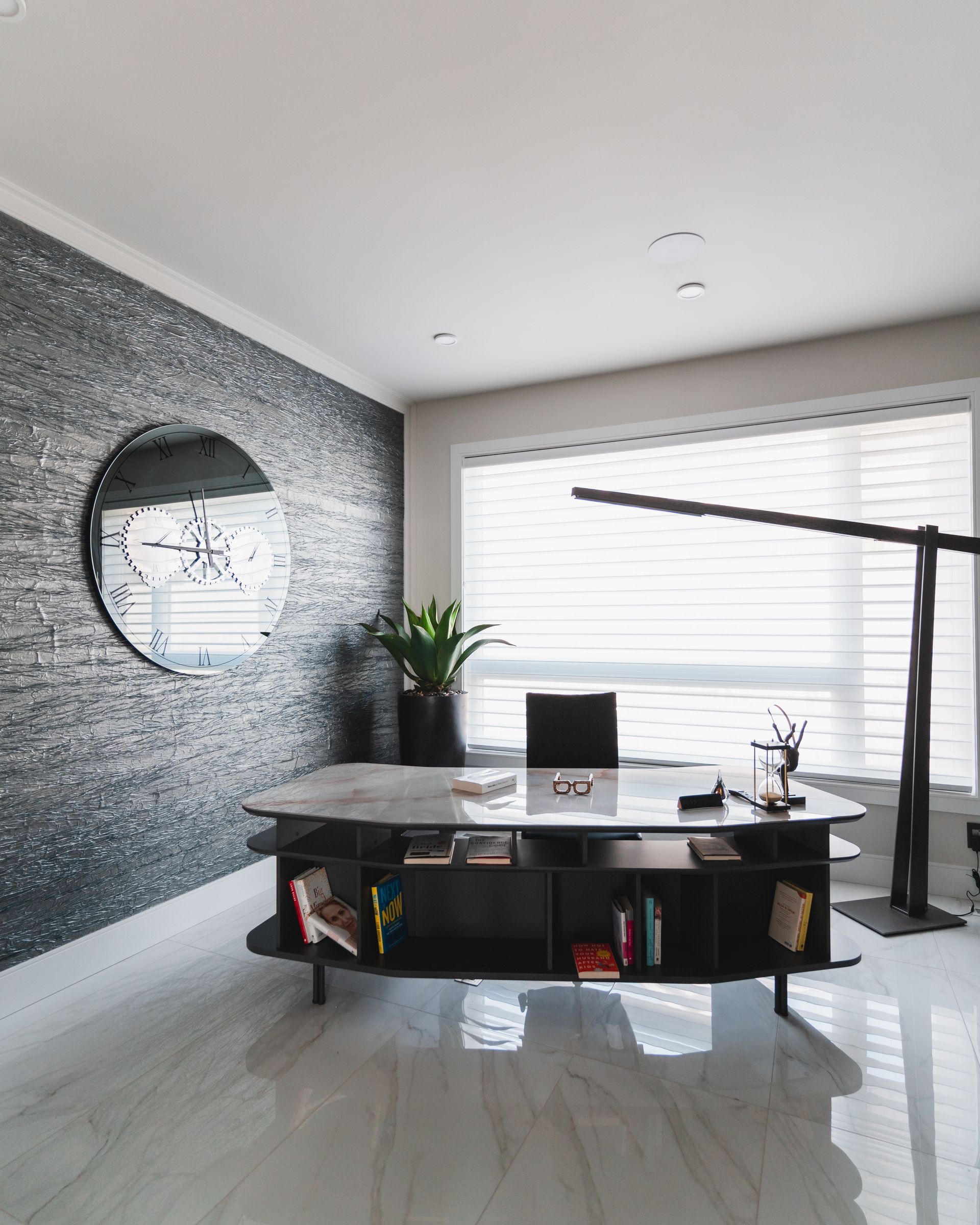 A room with a desk and a clock on the wall.