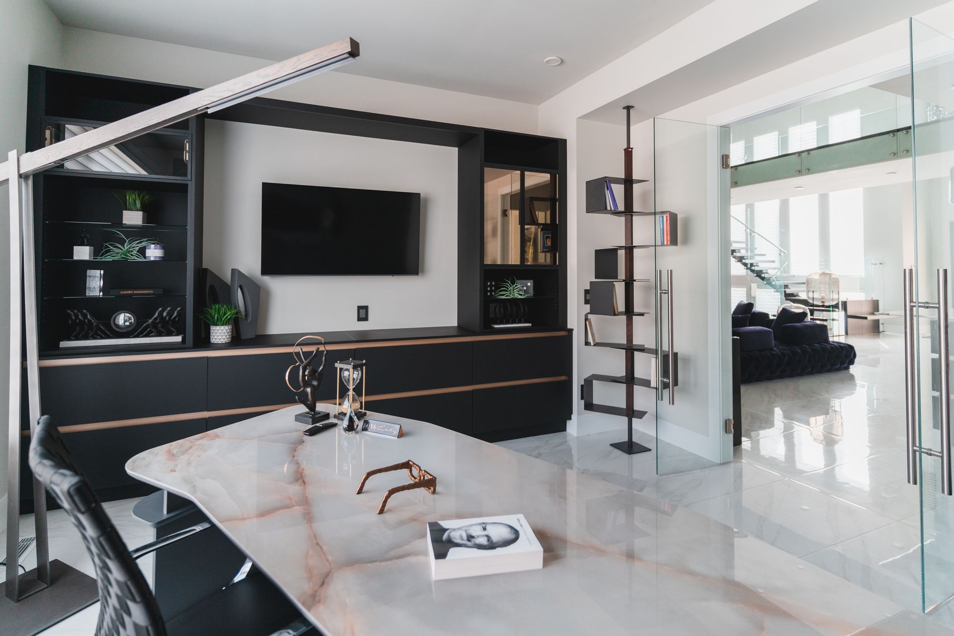 A living room with a table and a television on the wall.