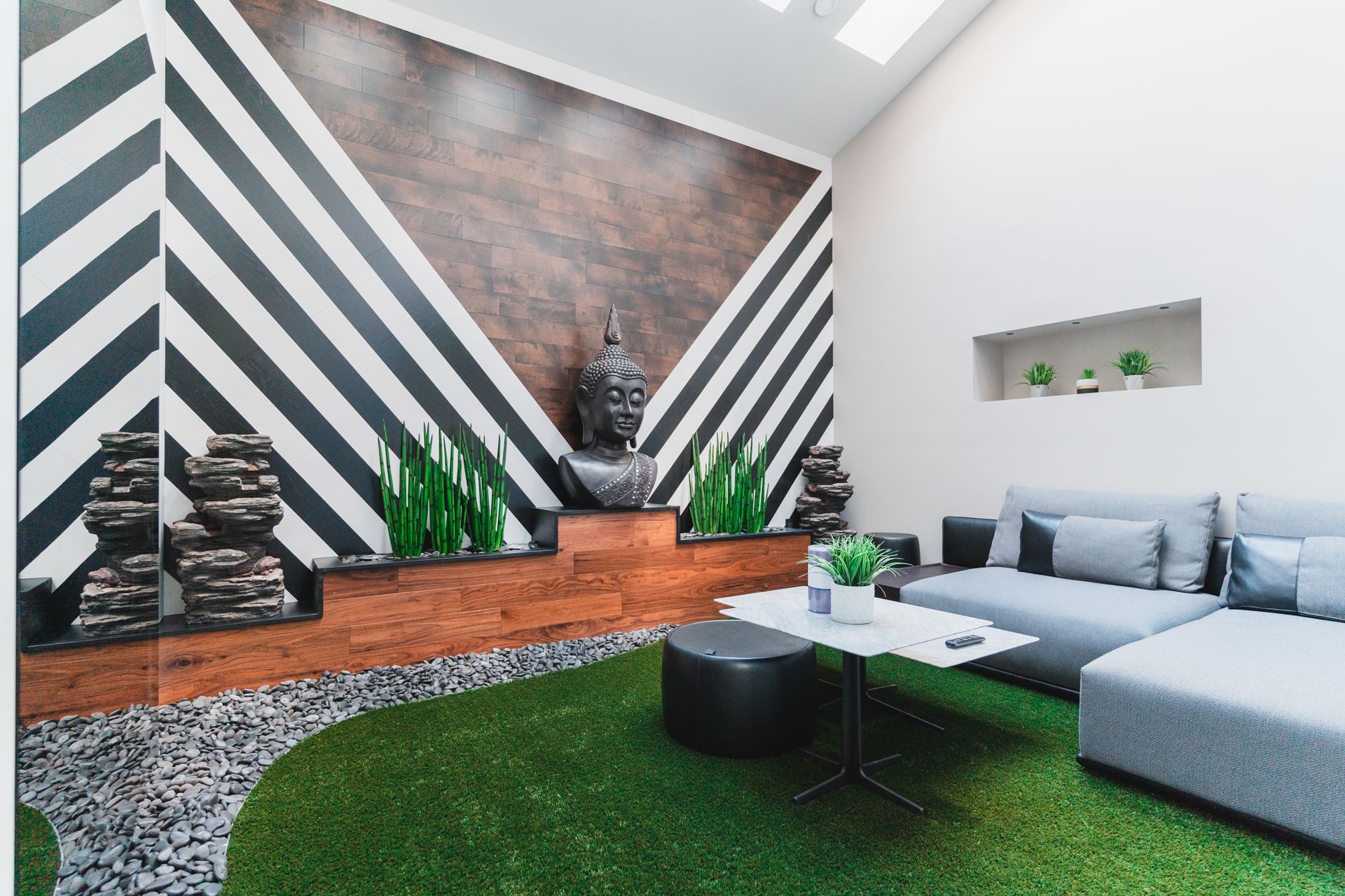 A living room with a couch , table , and a striped wall.