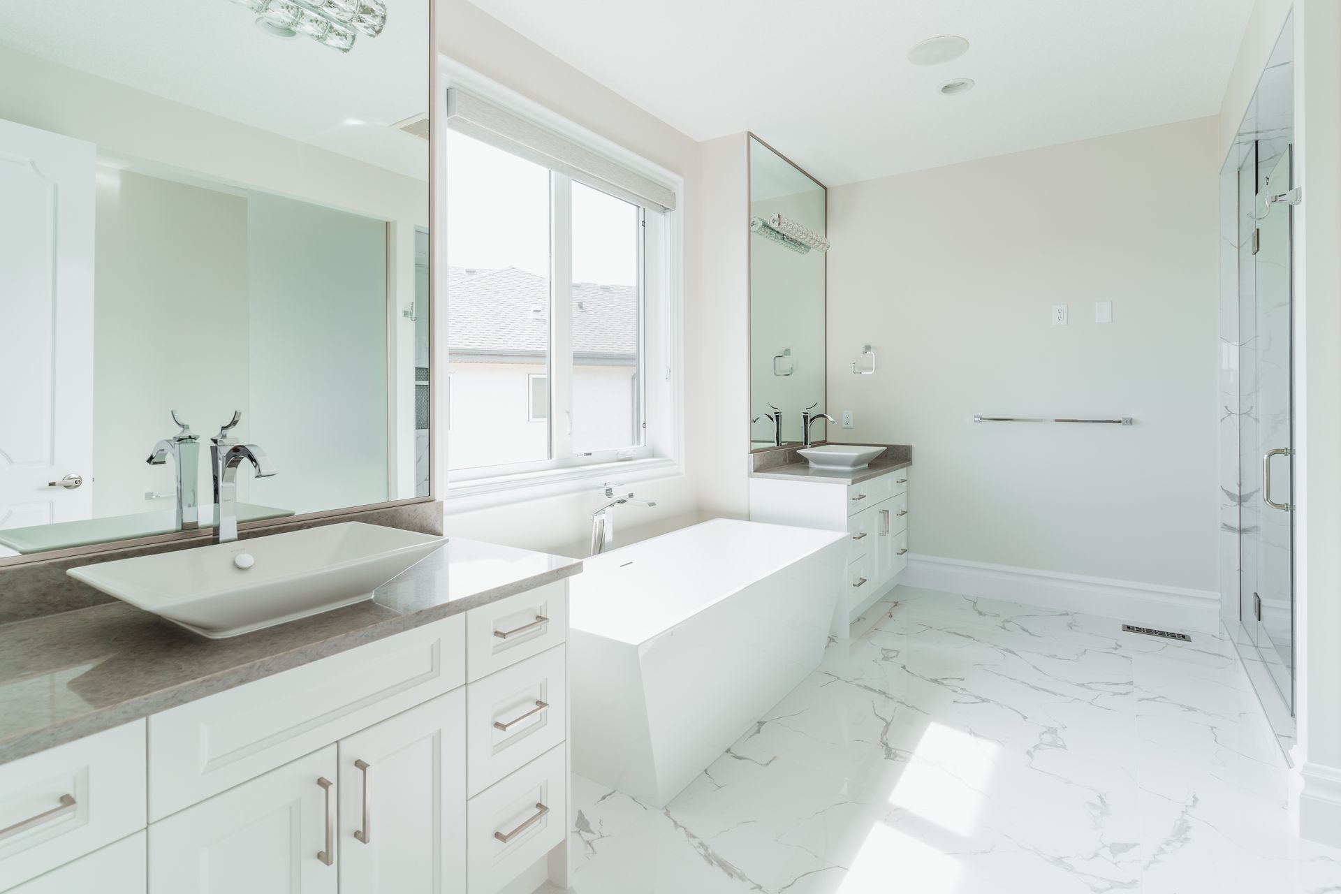 A bathroom with two sinks , a tub and a shower.