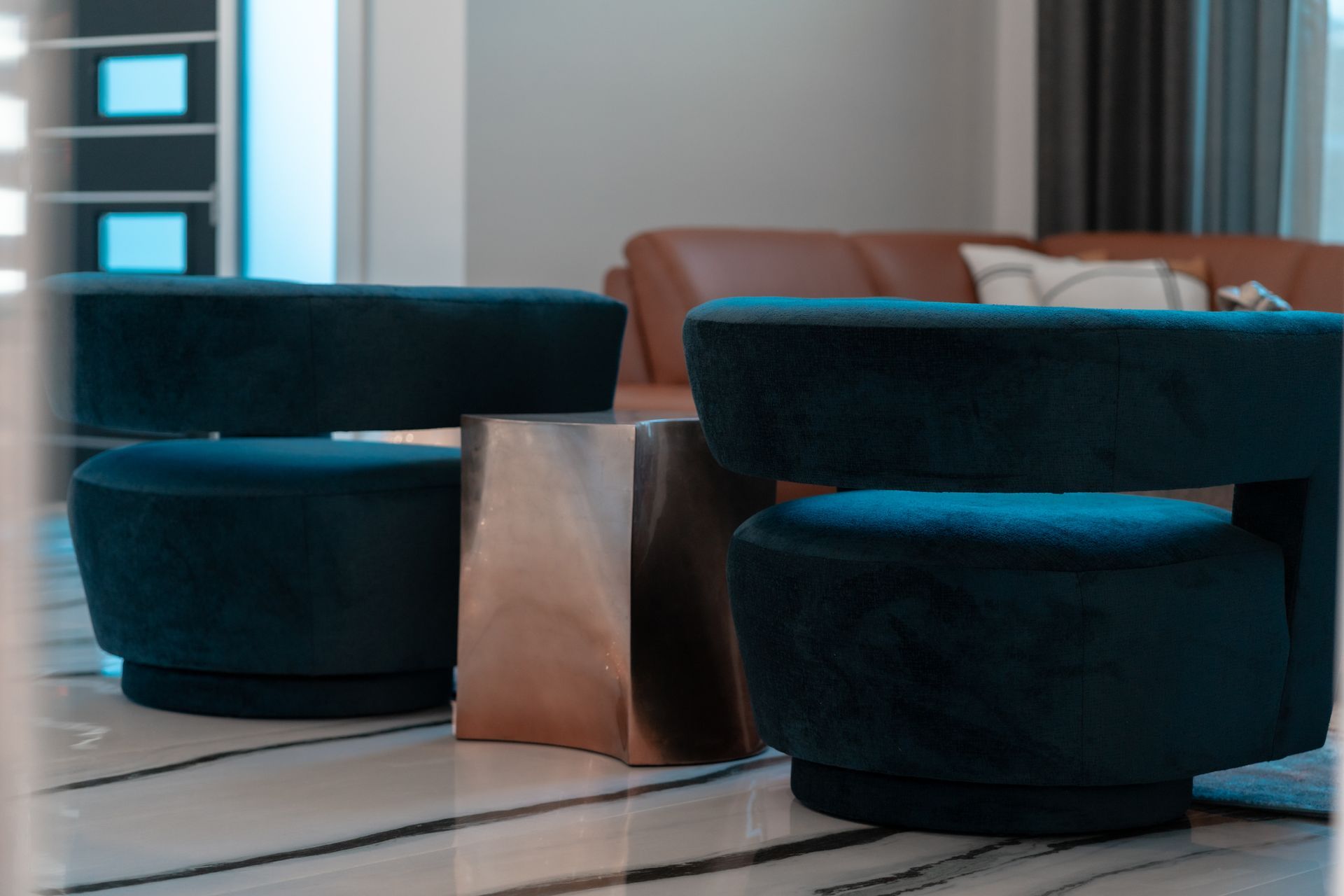 Two blue chairs are sitting next to each other in a living room.