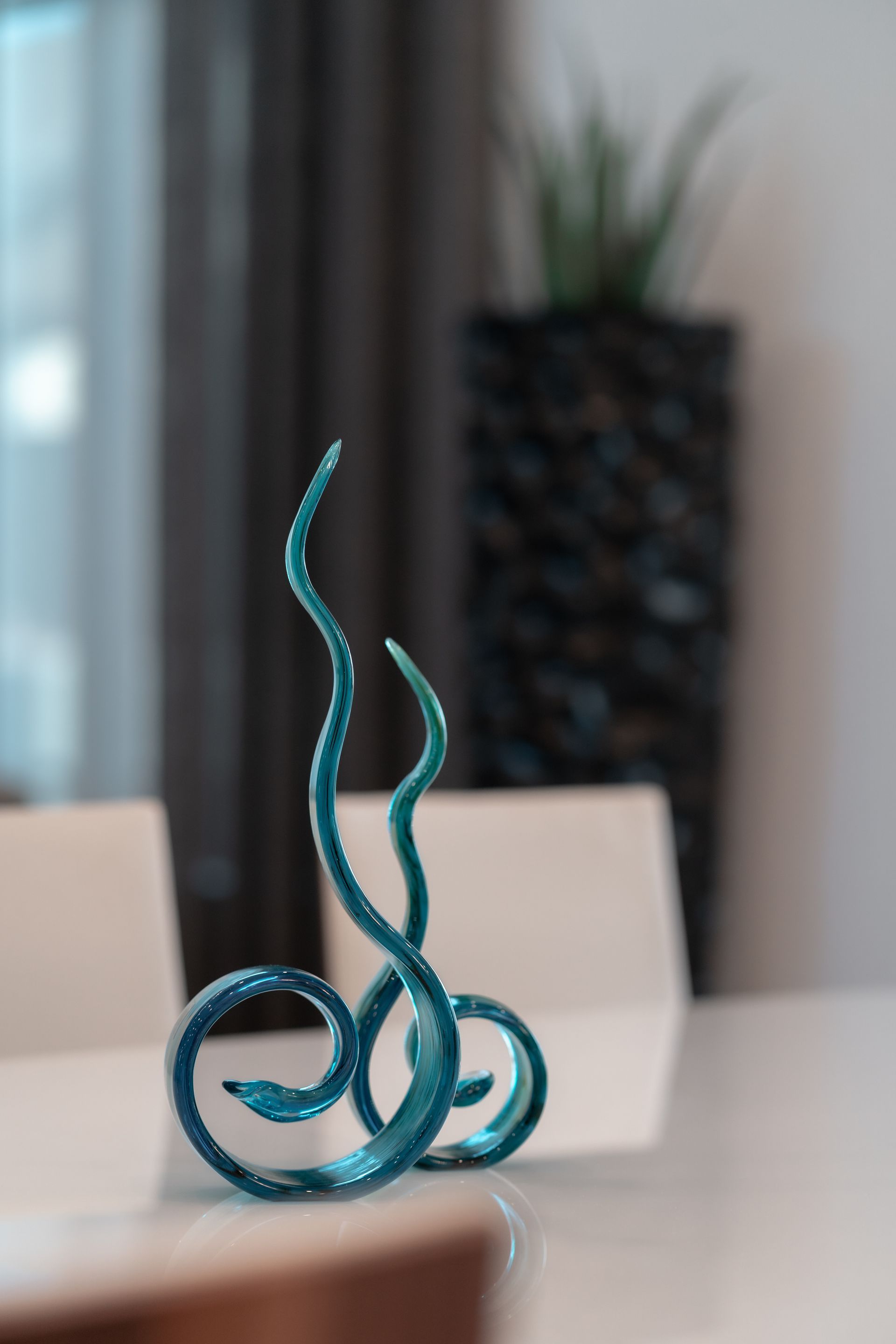 A blue sculpture is sitting on a table in a living room.