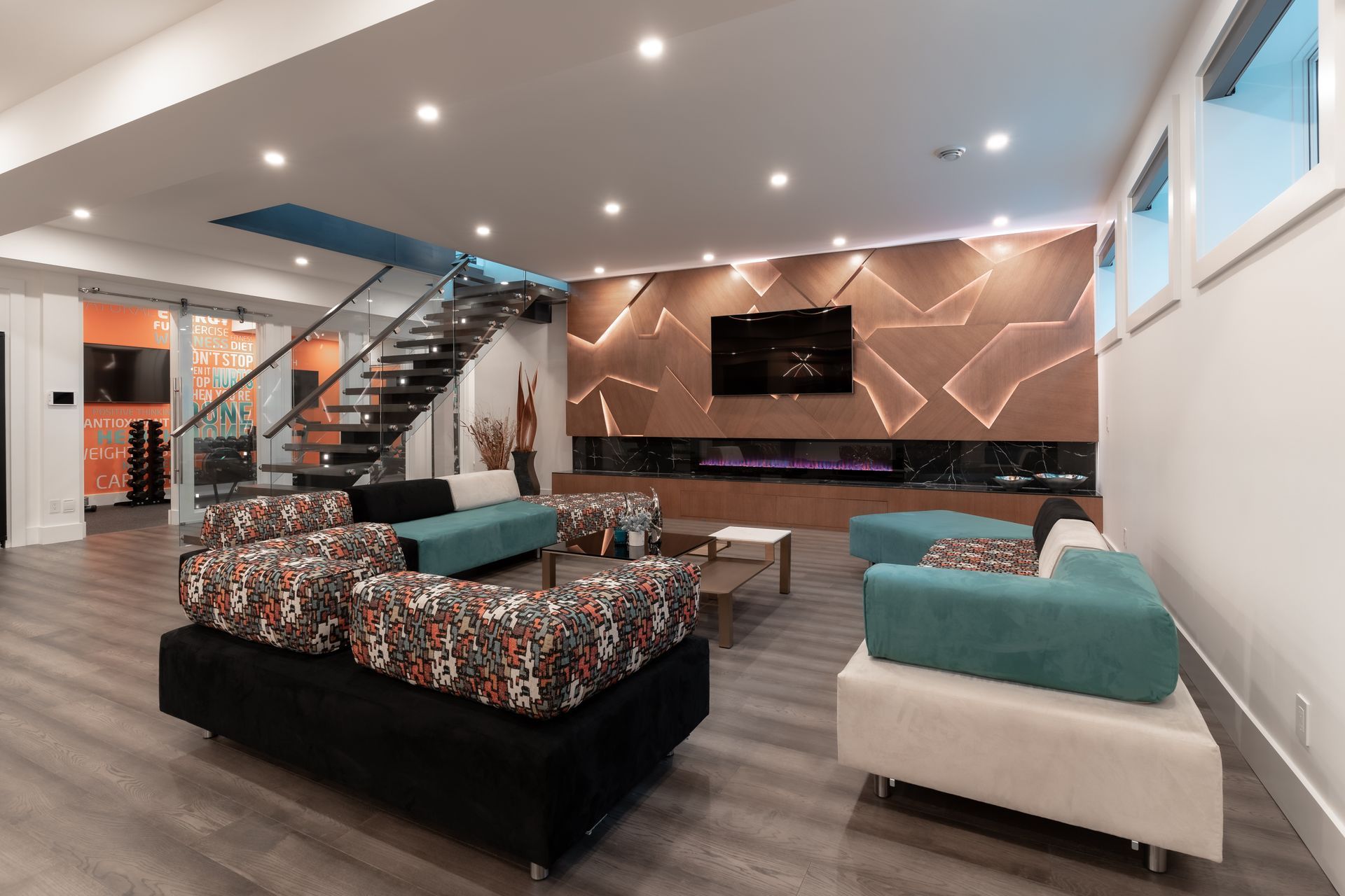 A living room with a couch , chairs , and stairs.