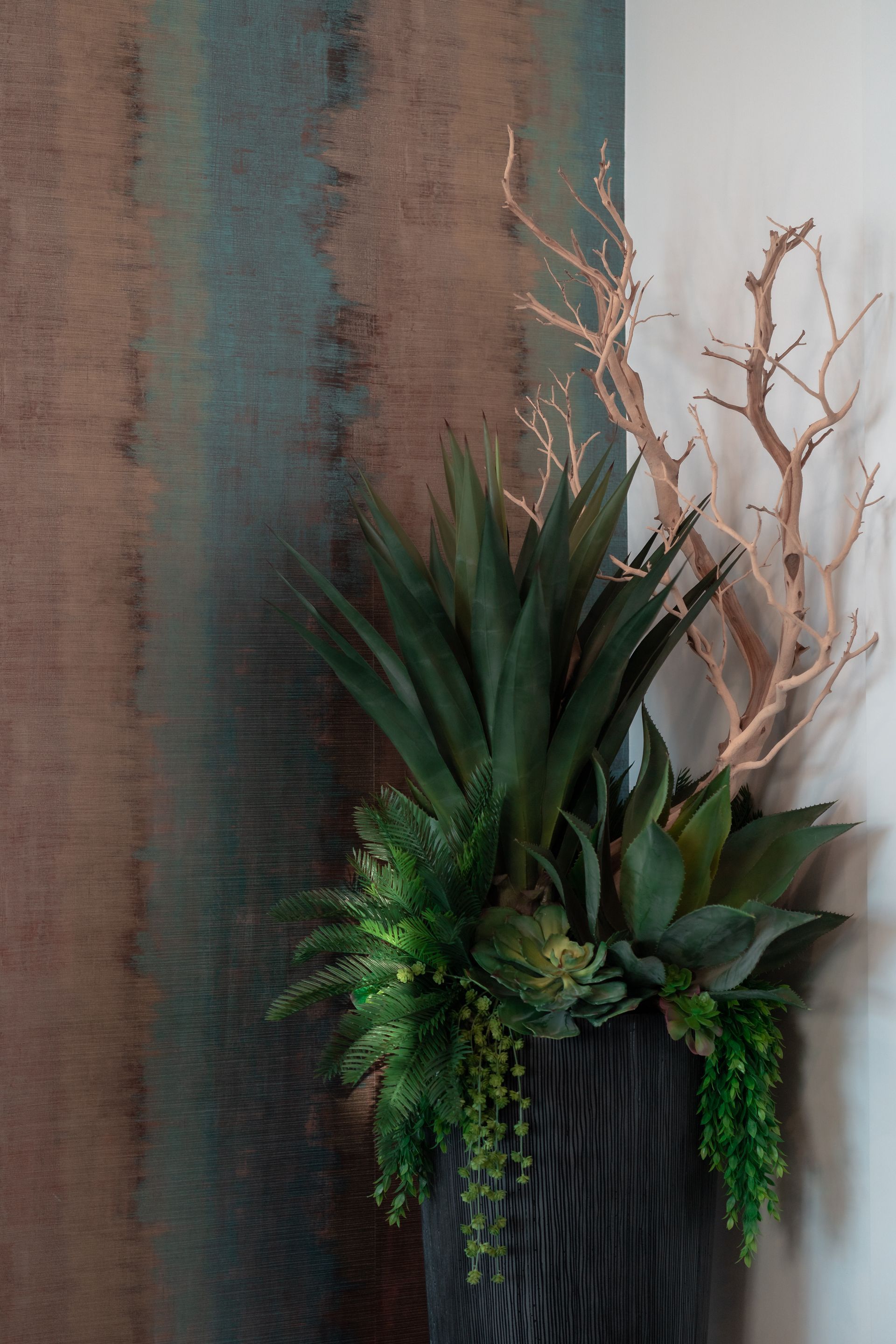 A potted plant is sitting in a corner of a room next to a wall.