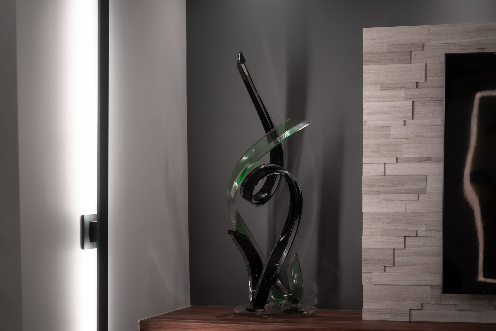 A glass sculpture is sitting on a wooden table in a living room.
