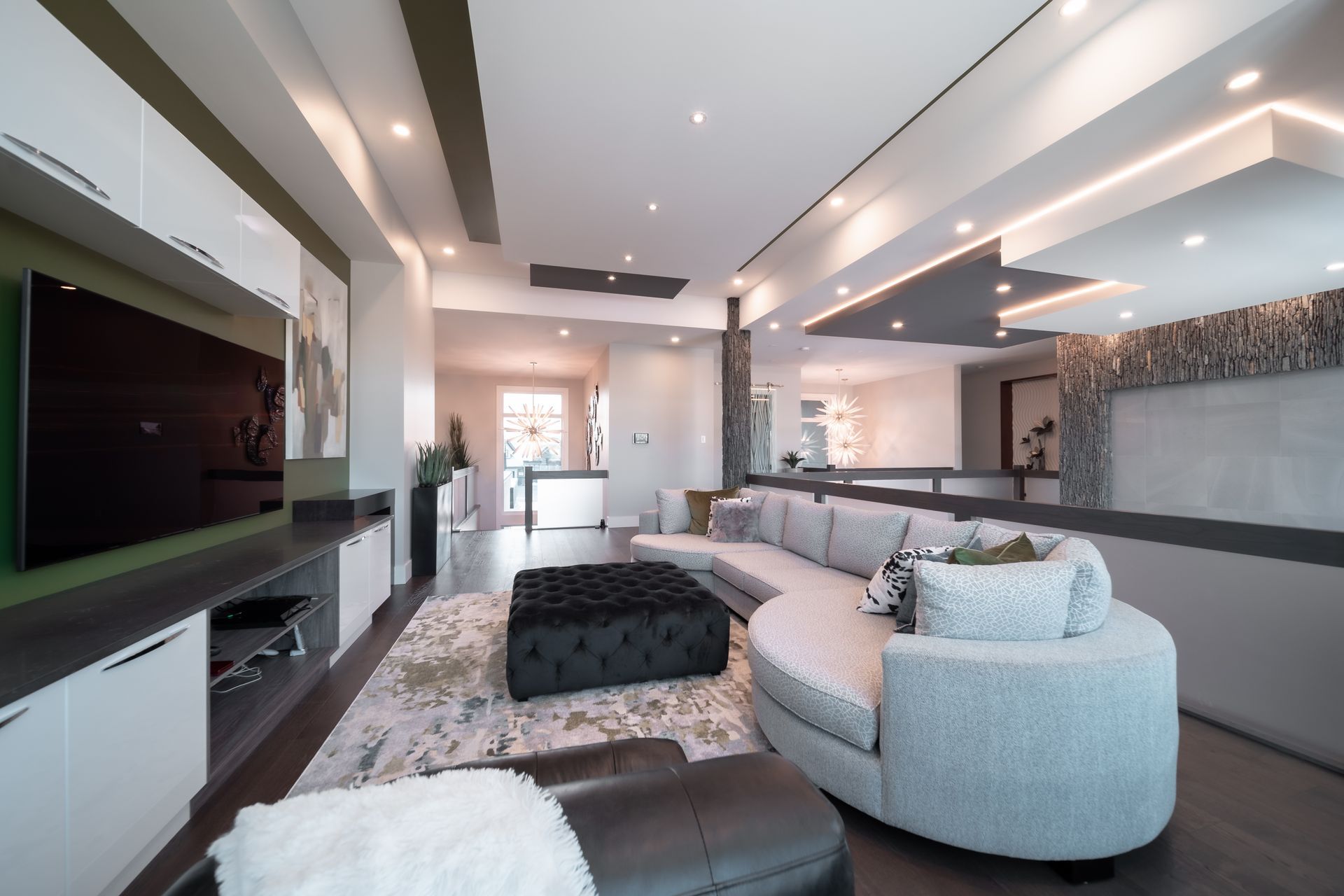 A living room with a round couch and a flat screen tv