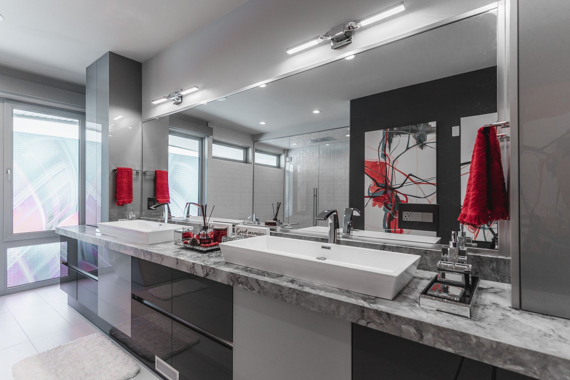 A bathroom with two sinks and a large mirror.