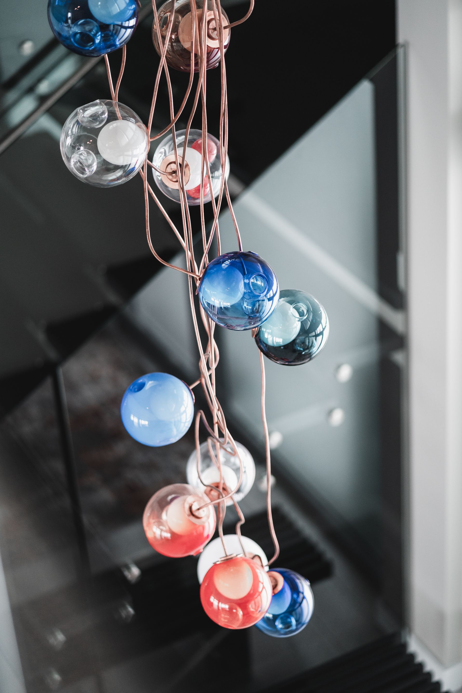 A bunch of colorful glass balls hanging from the ceiling