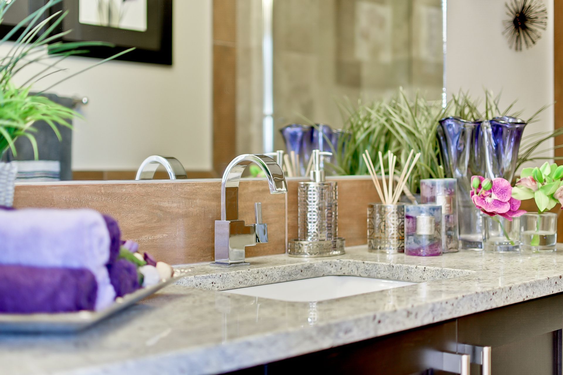 A bathroom with a sink , mirror and towels on the counter.