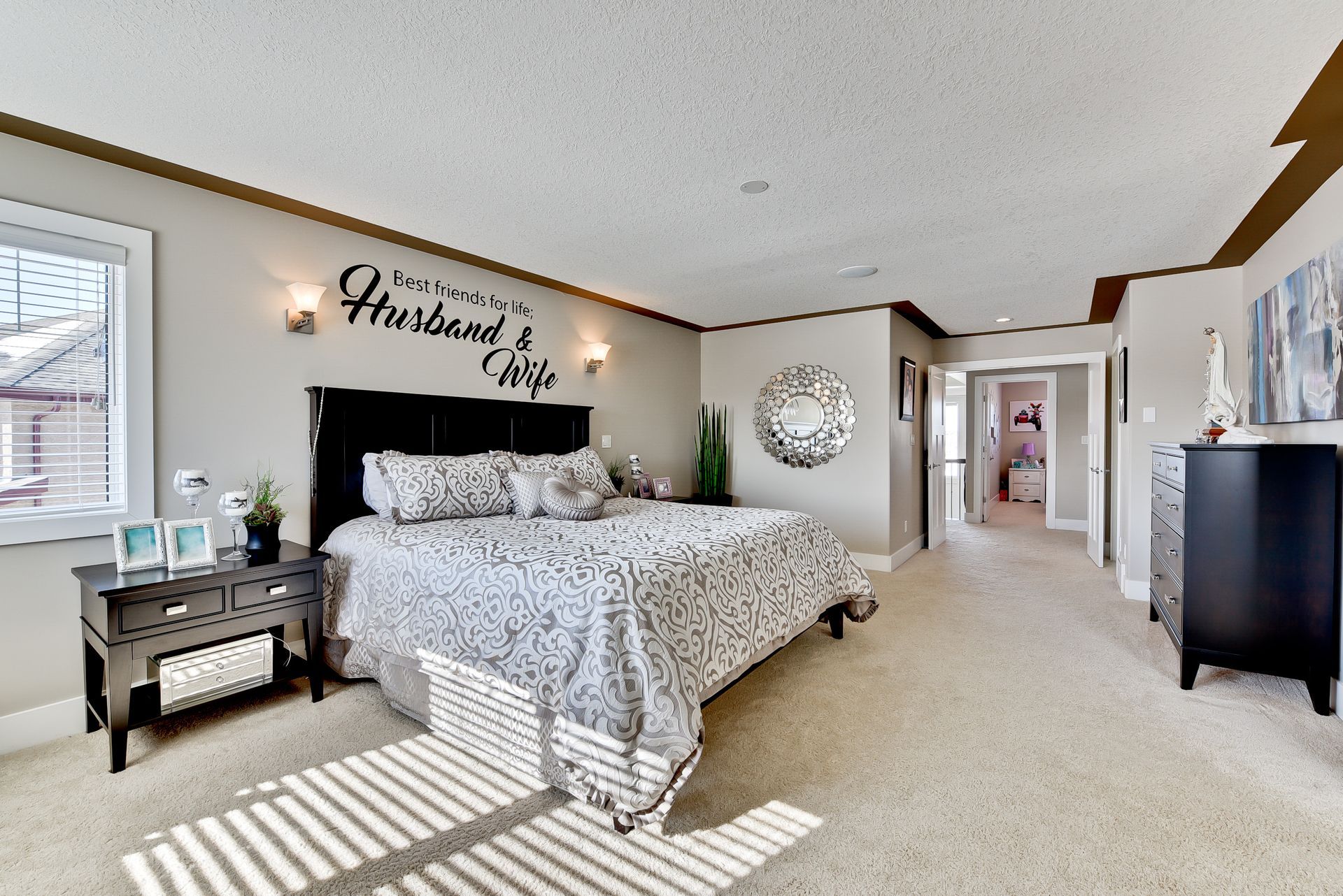 A bedroom with a large bed and a sign on the wall that says husband and wife