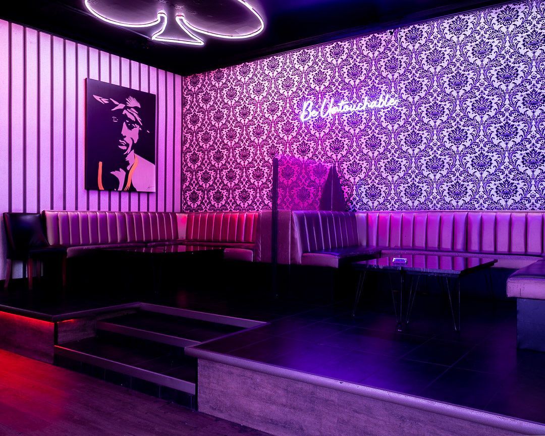 A 3d rendering of a room with purple lights and a stage.