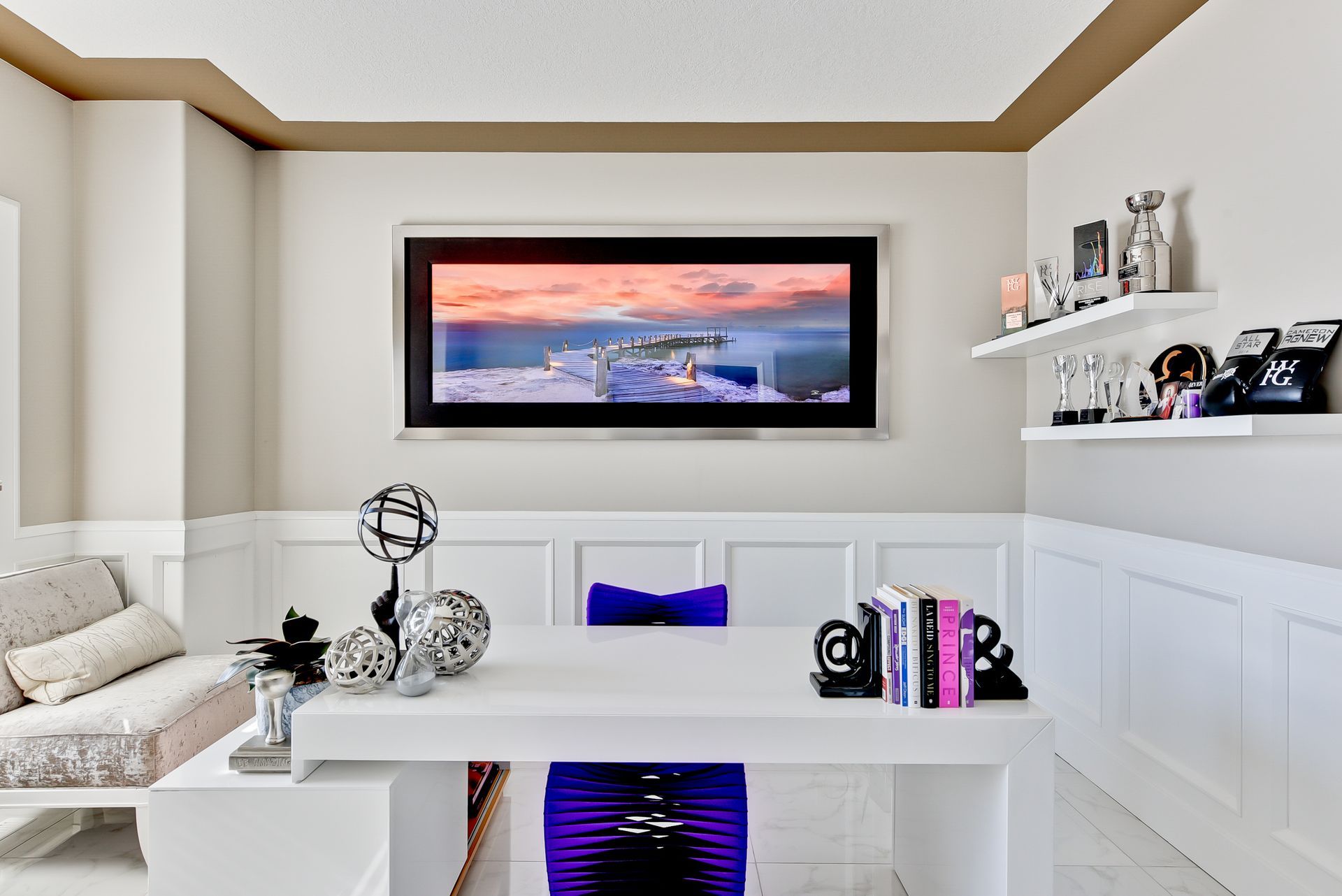 A living room with a desk and a picture on the wall