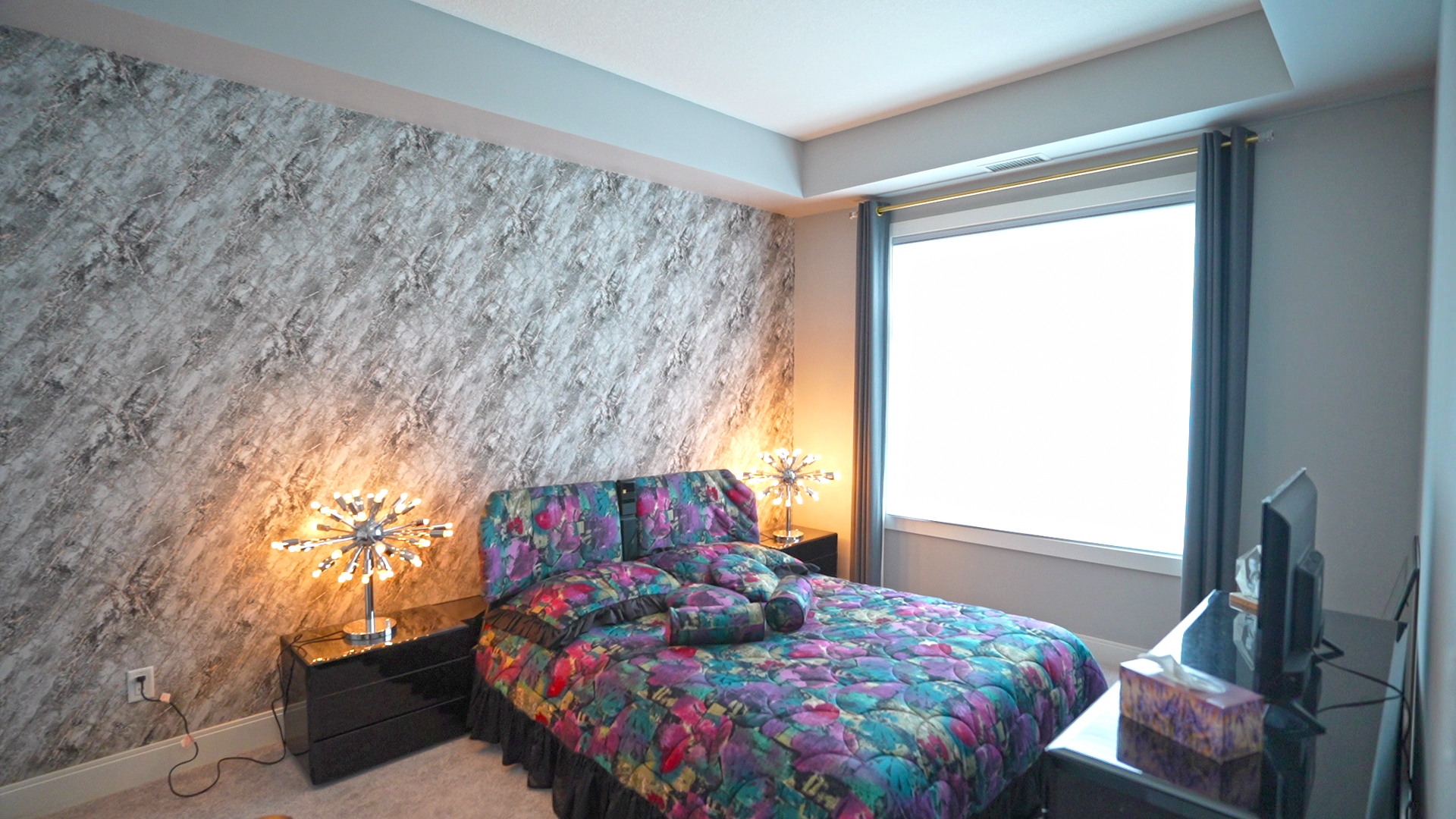 A bedroom with a bed , nightstand , and television.