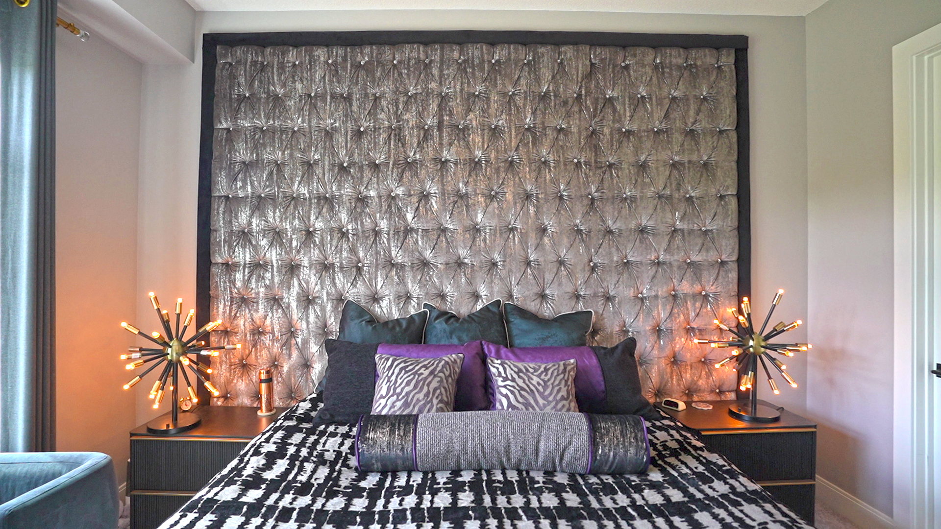 A bedroom with a bed , nightstands , and a headboard.