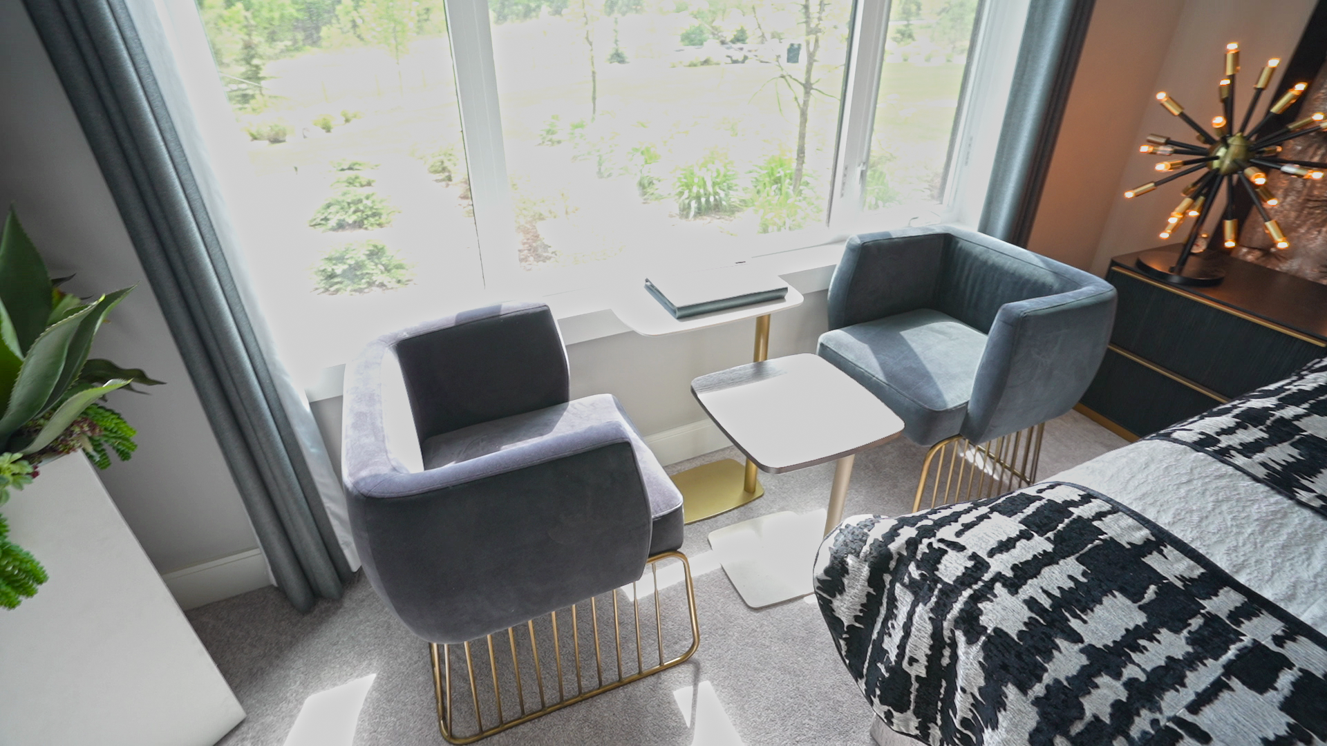 A bedroom with a bed , two chairs , a table and a window.