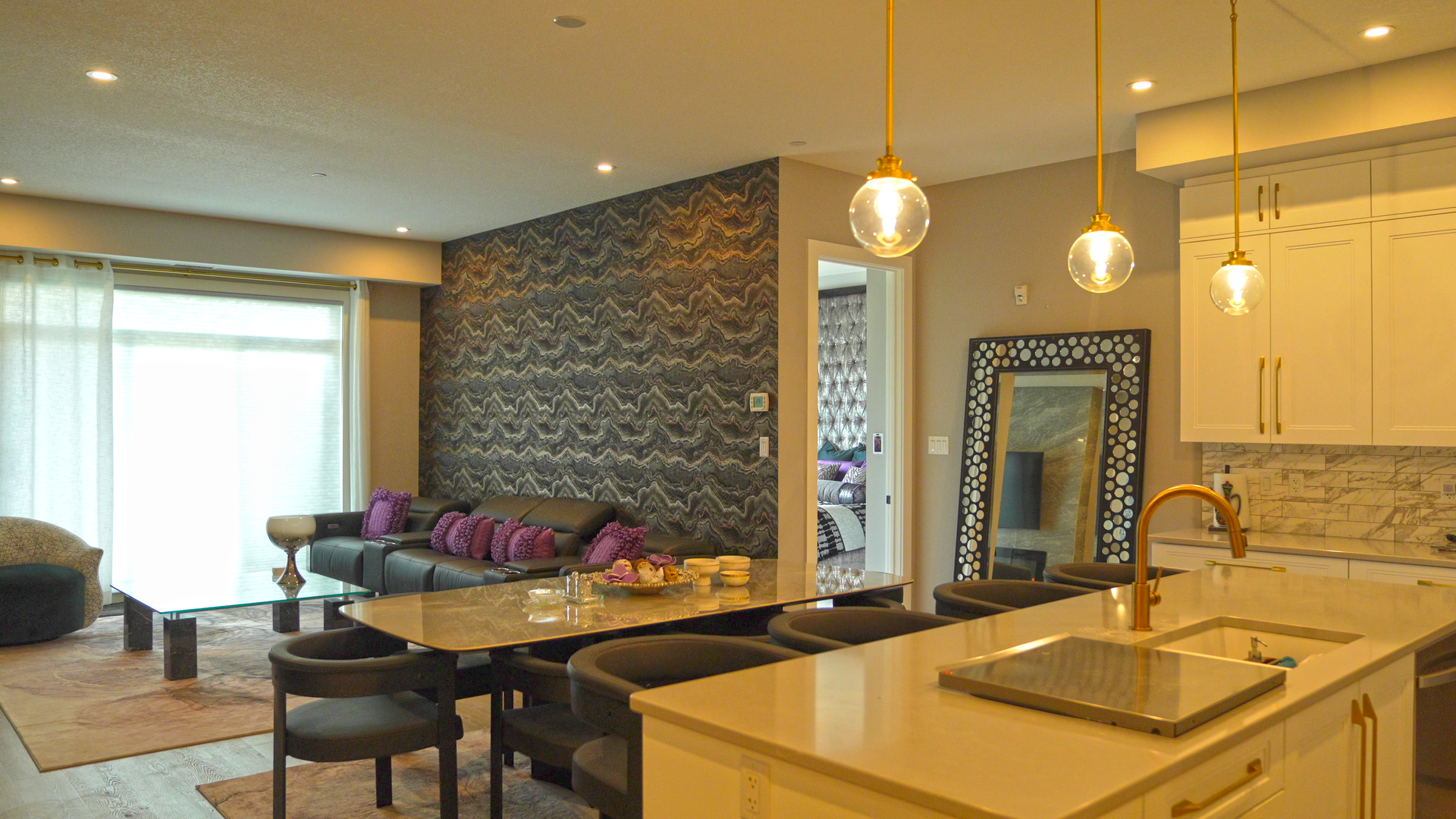A living room with a couch , table , chairs and a kitchen.