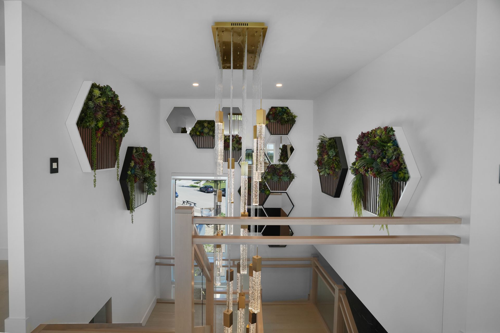 A staircase in a house with plants hanging from the ceiling.