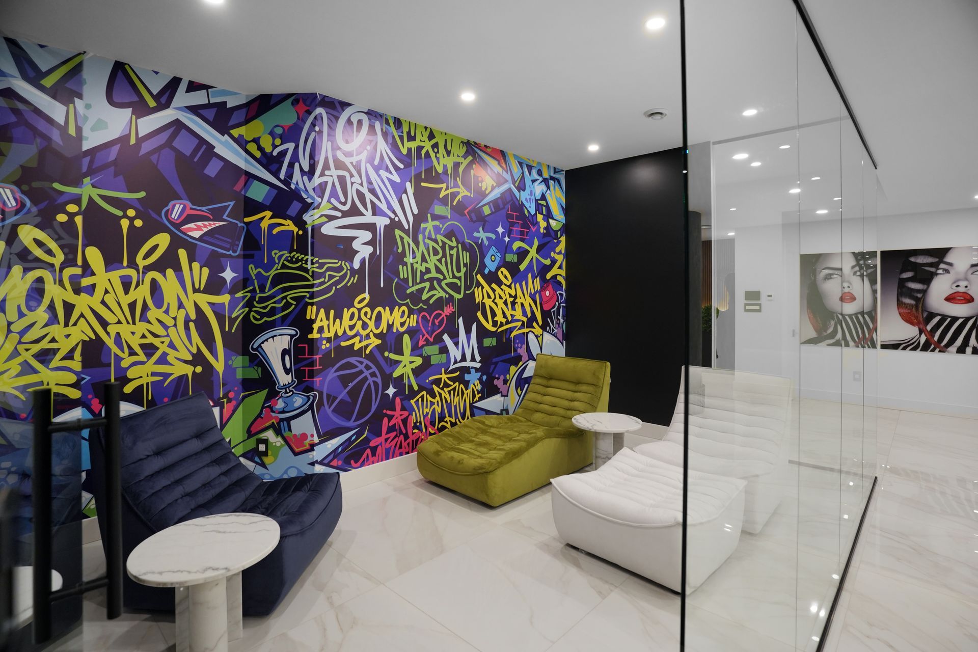 A room with a graffiti wall and chairs and tables.