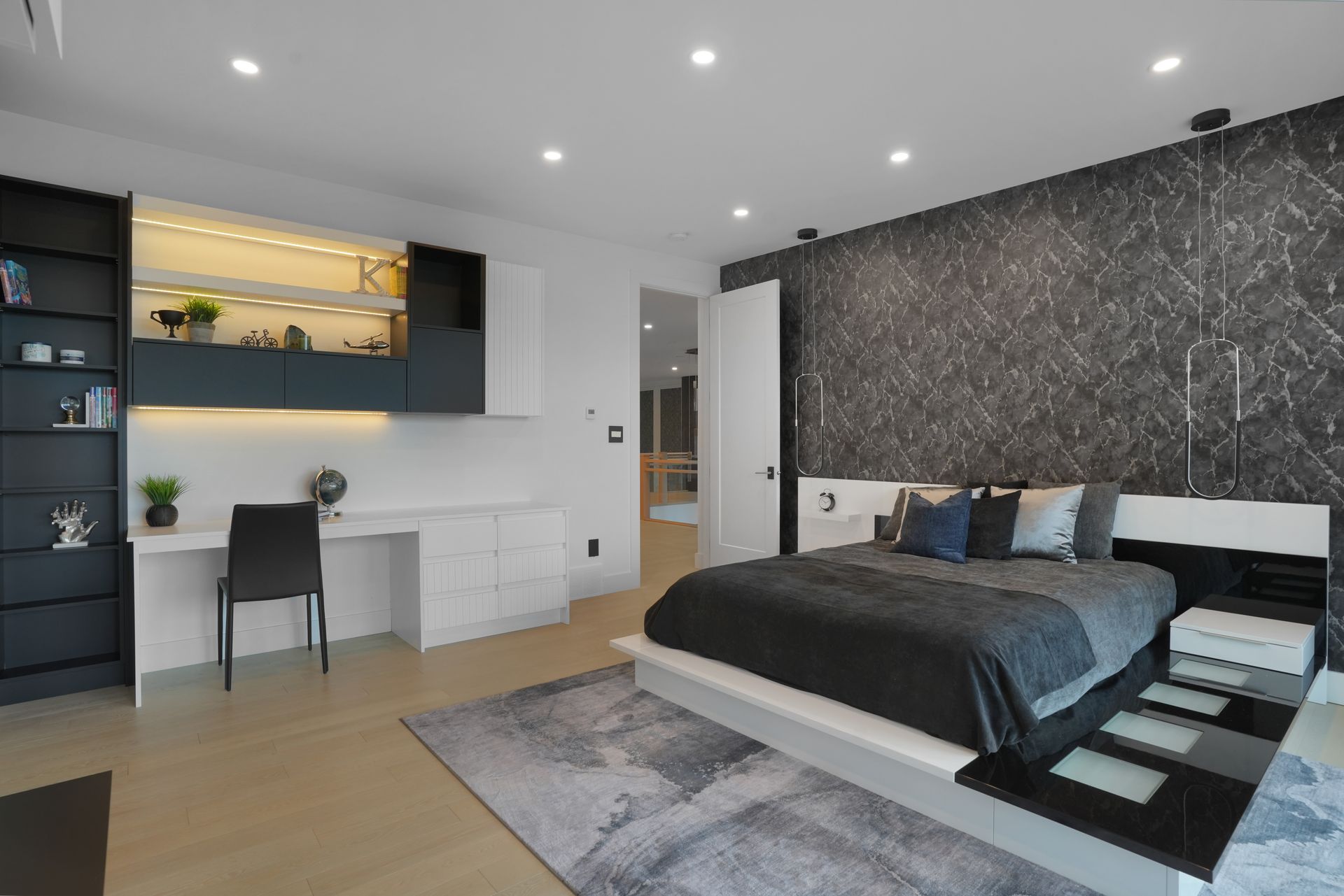 A bedroom with a large bed and a desk.