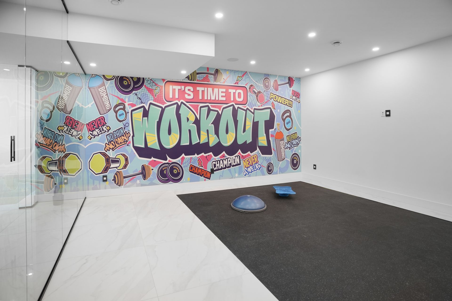 A room with a mural on the wall that says it 's time to workout