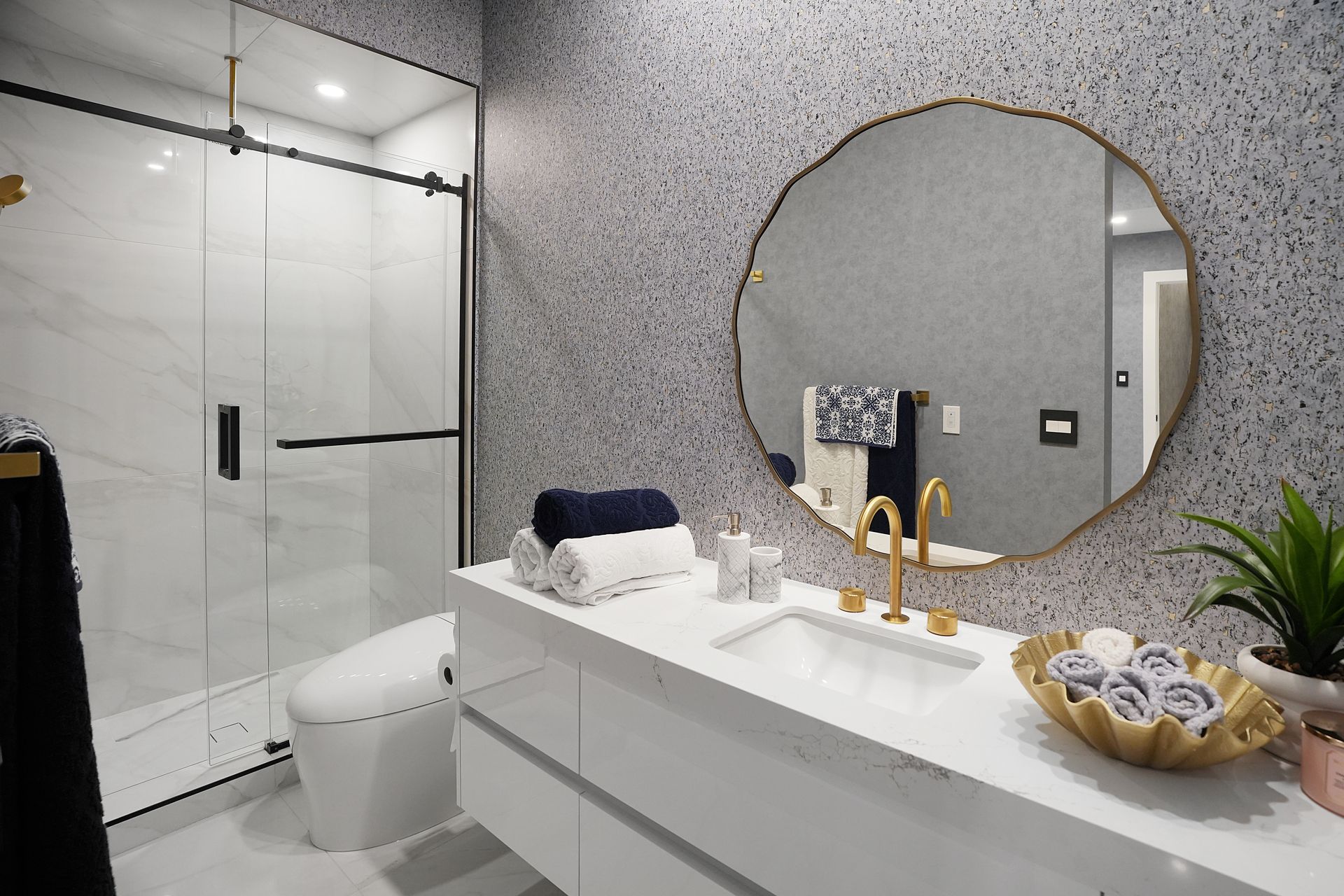 A bathroom with a sink , toilet , shower and mirror.